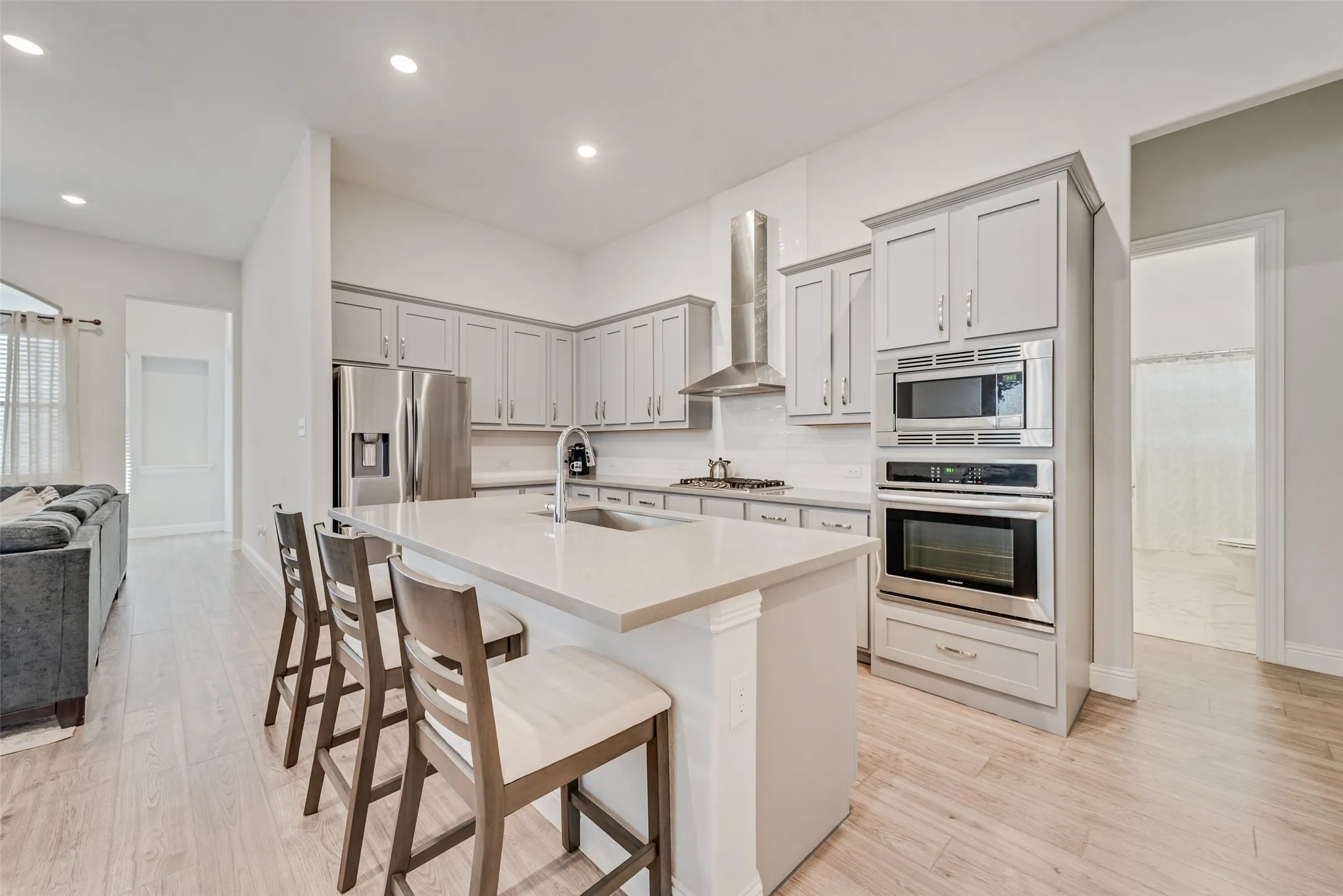 Open kitchen with engineered hardwood floors, shaker cabinets, quartz countertops,  and 11 ft ceilings at 1721 Pattenson Trl, Haslet, TX 76052 in Wellington subdivision