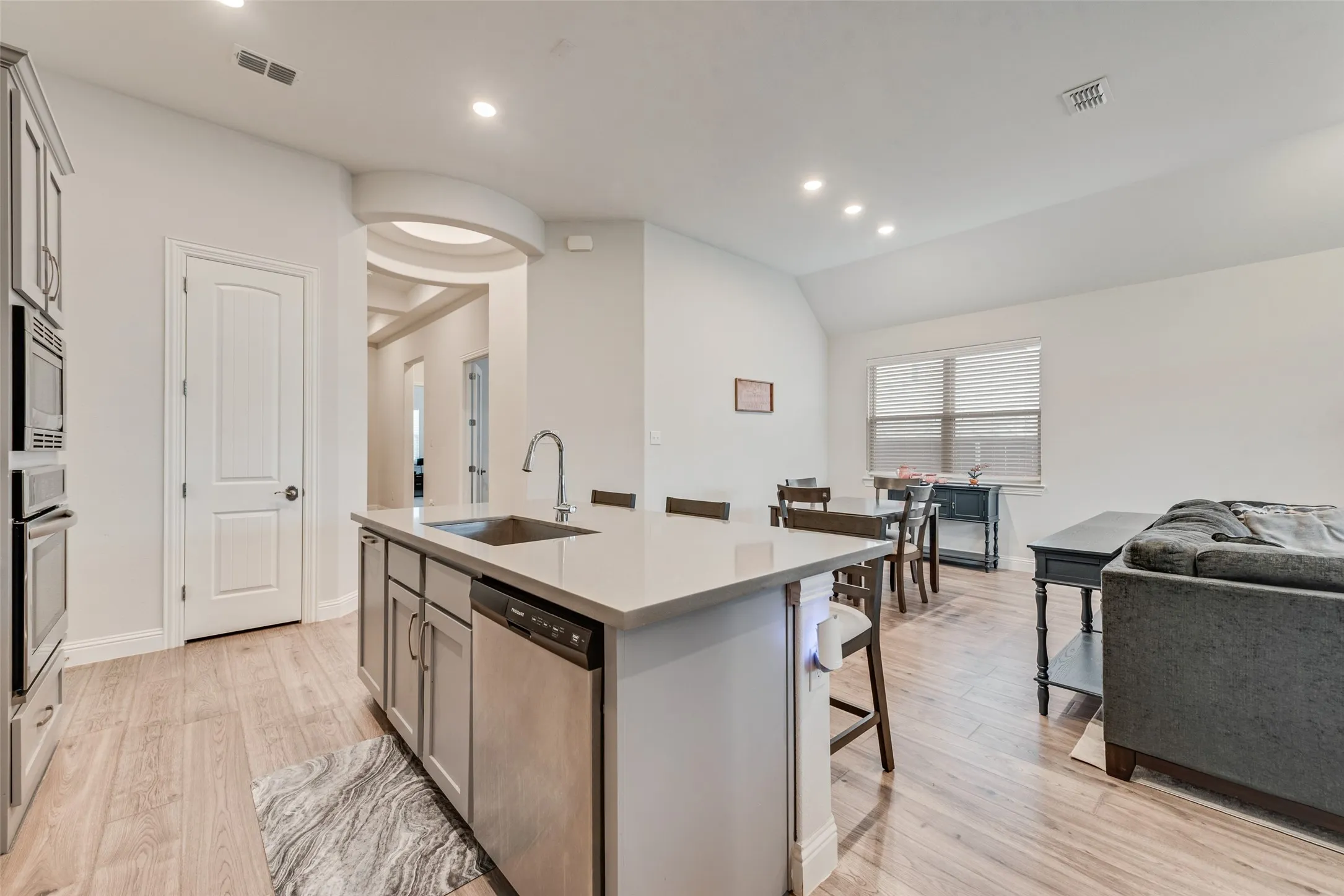 Open kitchen with engineered hardwood floors, shaker cabinets, quartz countertops,  and 11 ft ceilings at 1721 Pattenson Trl, Haslet, TX 76052 in Wellington subdivision
