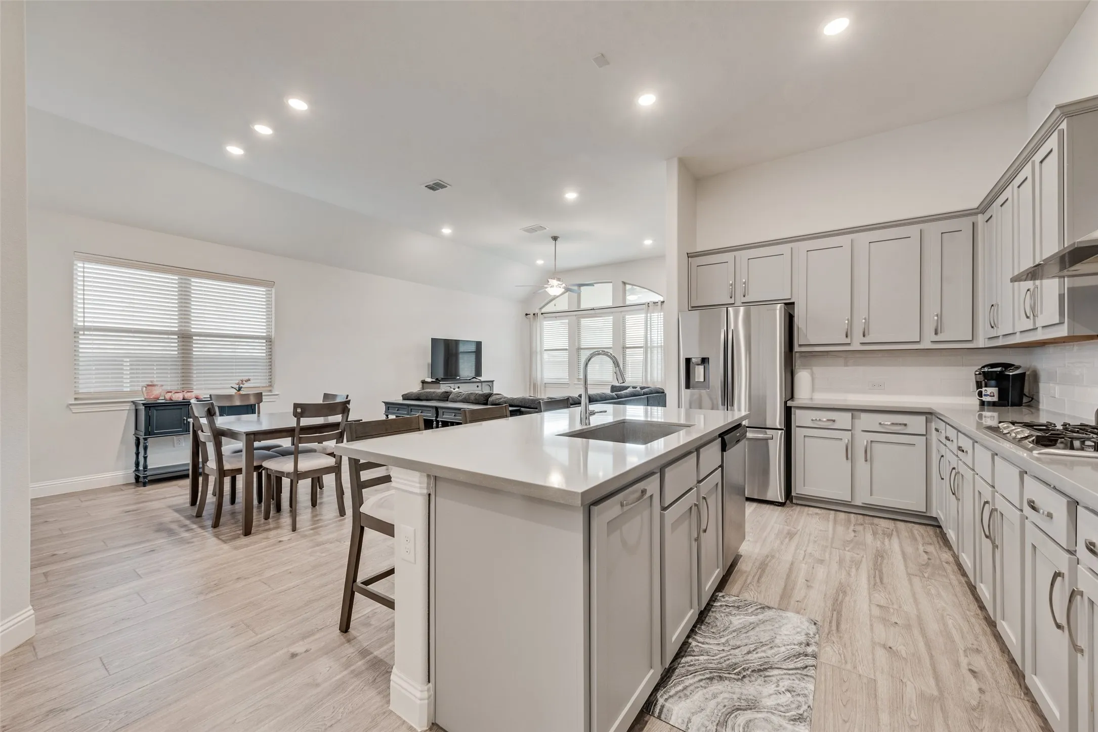Open kitchen with engineered hardwood floors, shaker cabinets, quartz countertops,  and 11 ft ceilings at 1721 Pattenson Trl, Haslet, TX 76052 in Wellington subdivision