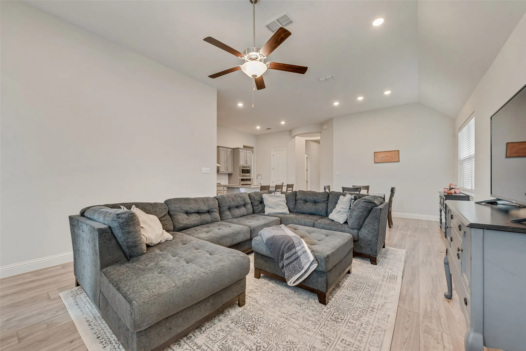 Living room with engineered hardwood floors and 11 ft ceilings at 1721 Pattenson Trl, Haslet, TX 76052 in Wellington subdivision