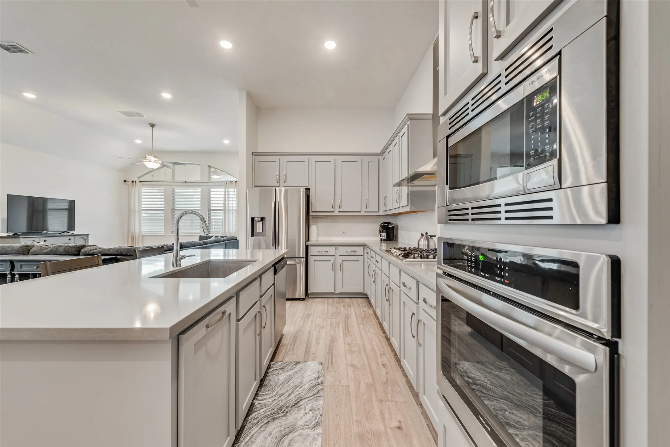 Open kitchen with engineered hardwood floors, shaker cabinets, quartz countertops,  and 11 ft ceilings at 1721 Pattenson Trl, Haslet, TX 76052 in Wellington subdivision