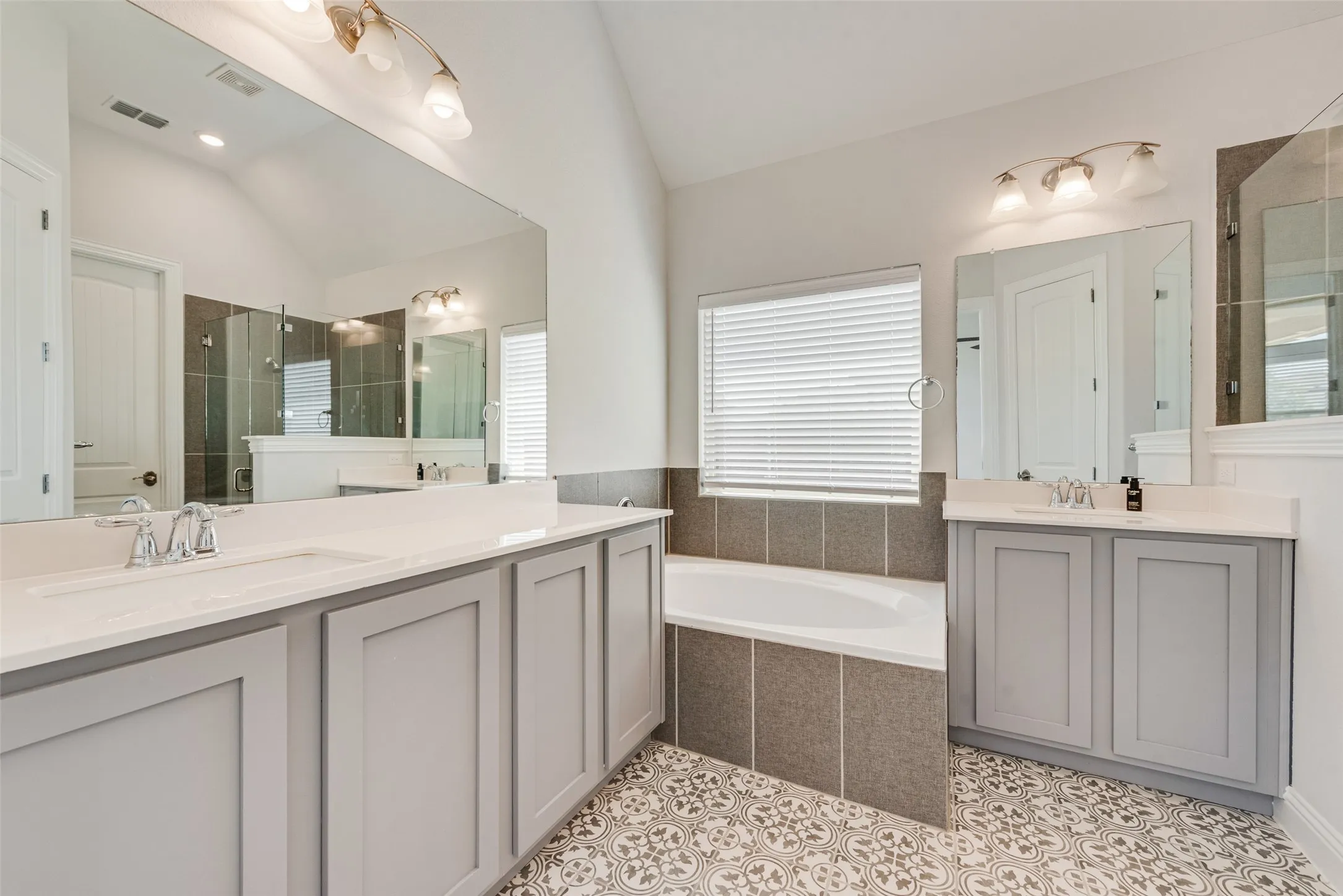 Primary bathroom with gorgeous tile floors, shaker cabinets and 11 ft ceilings at 1721 Pattenson Trl, Haslet, TX 76052 in Wellington subdivision
