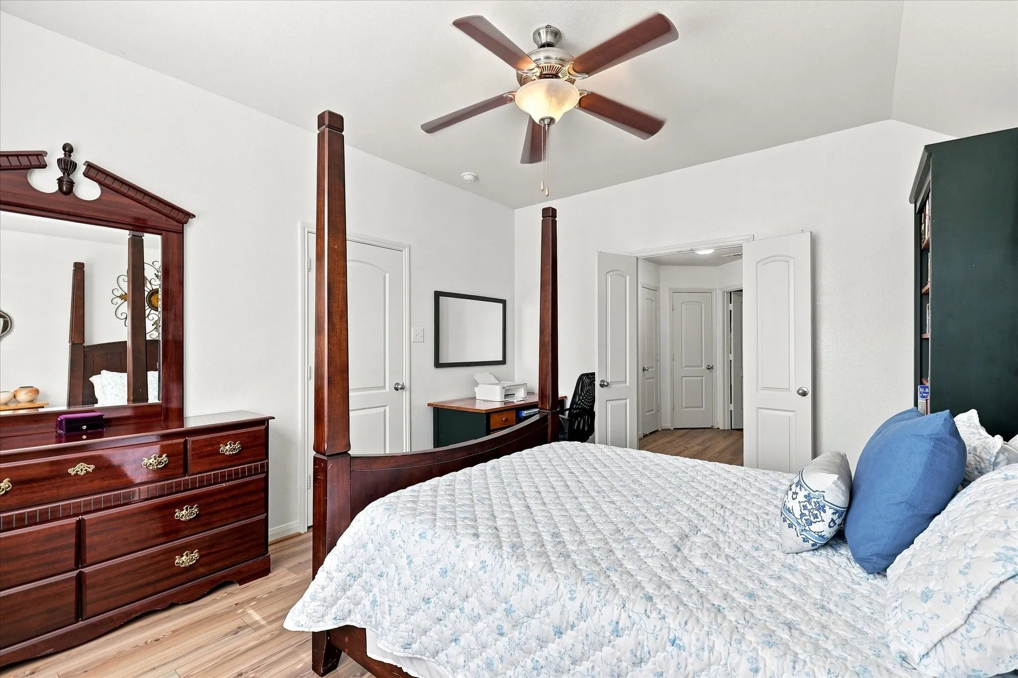 The private primary suite is split from secondary bedrooms for maximum privacy. It showcases beautiful wood-finish flooring, crisp white walls, and a large window looking out to the private backyard