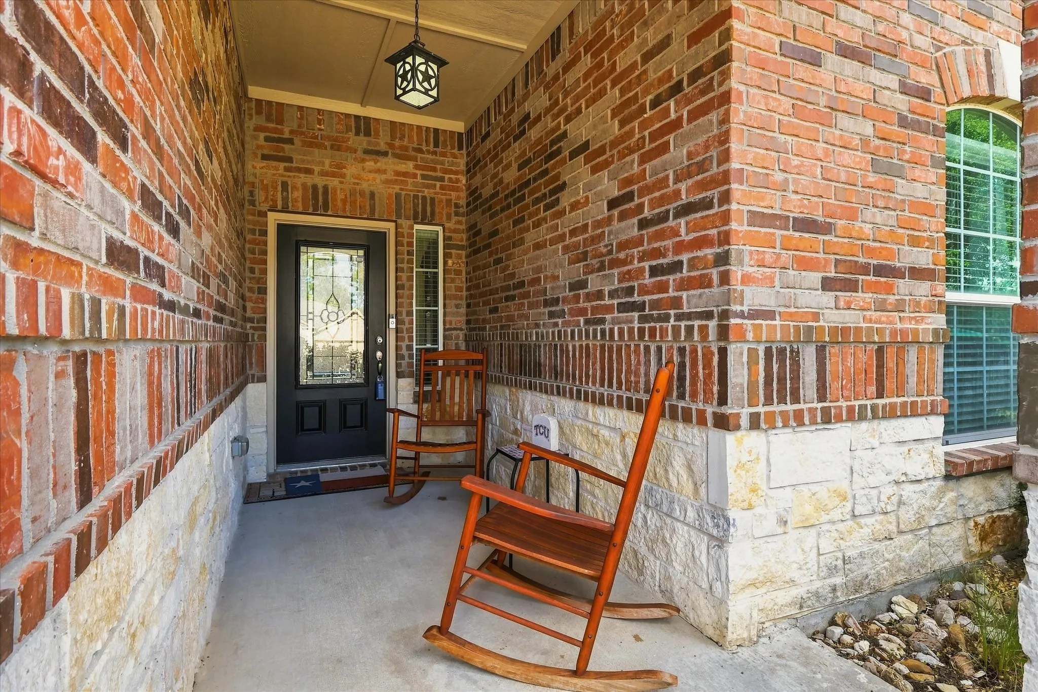 A welcoming brick front porch with plenty of space for rocking chairs. This cozy entryway introduces the warm, suburban charm of this Anna, Texas home.