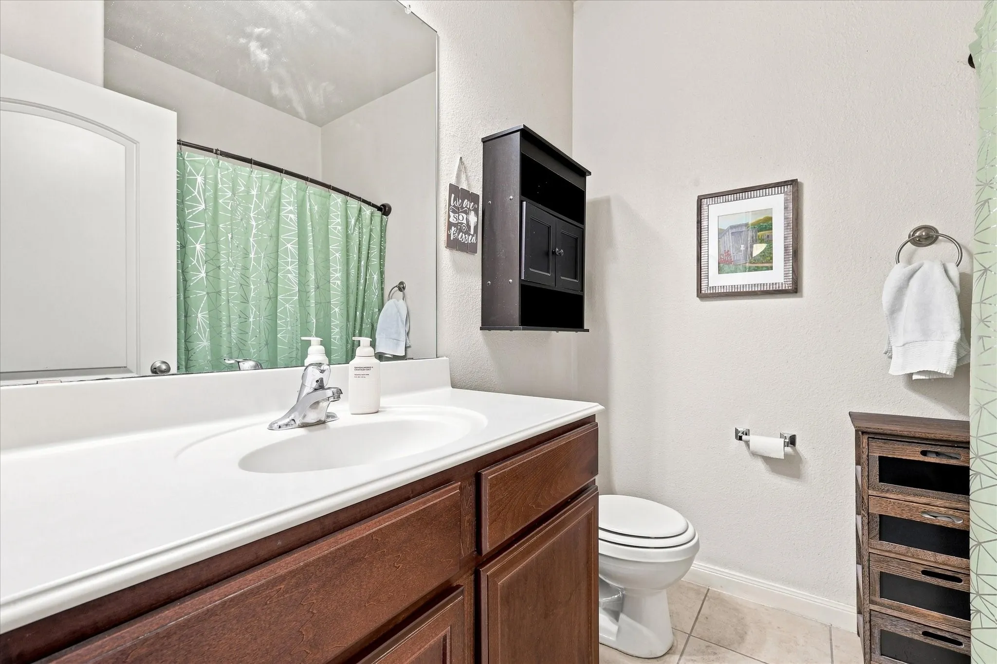 White integrated sink with a chrome faucet, set into a wood-finish vanity with panel-front cabinetry