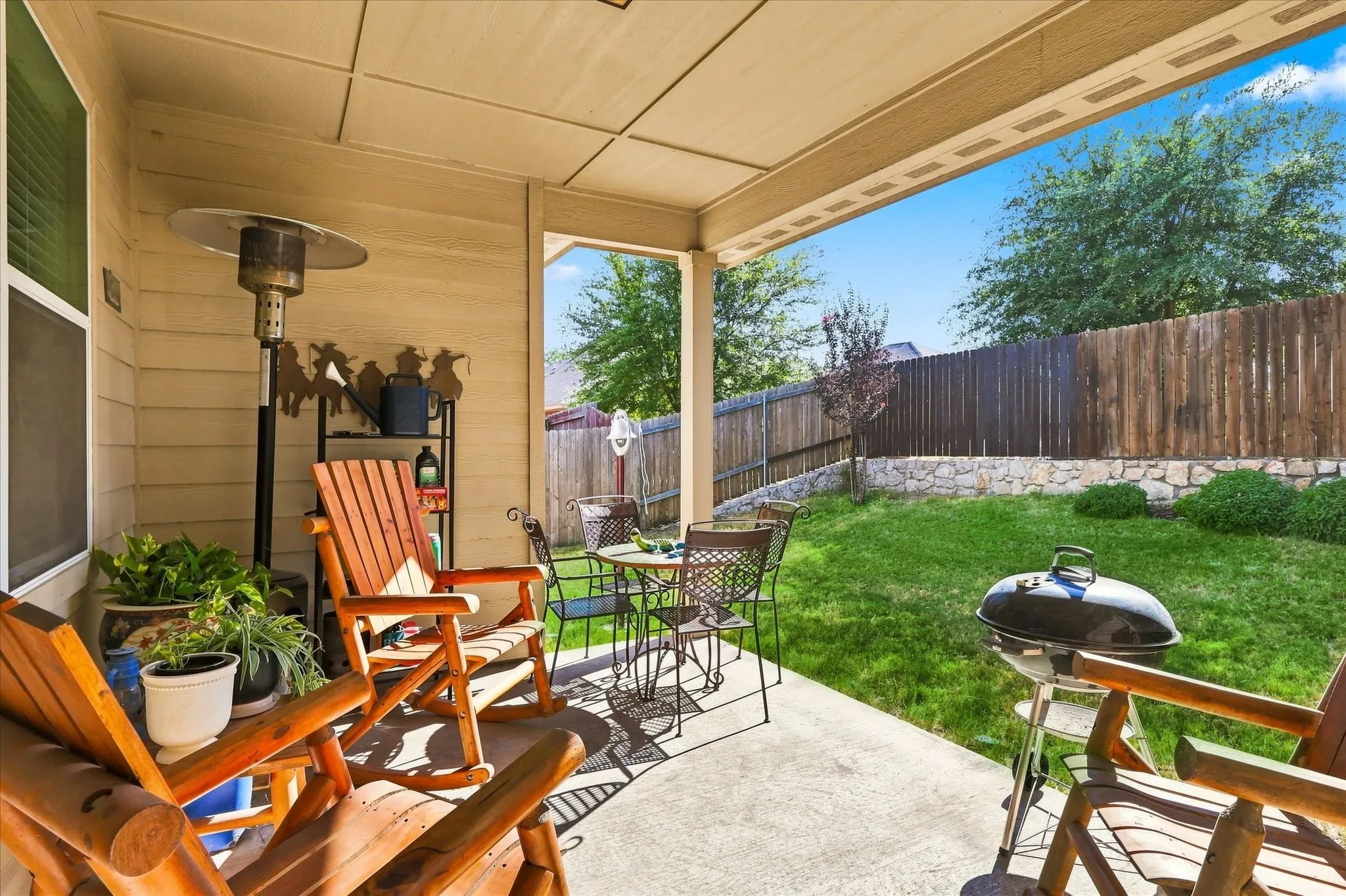 Large, private backyard with tall wood privacy fence and covered patio in Oak Hollow subdivision.