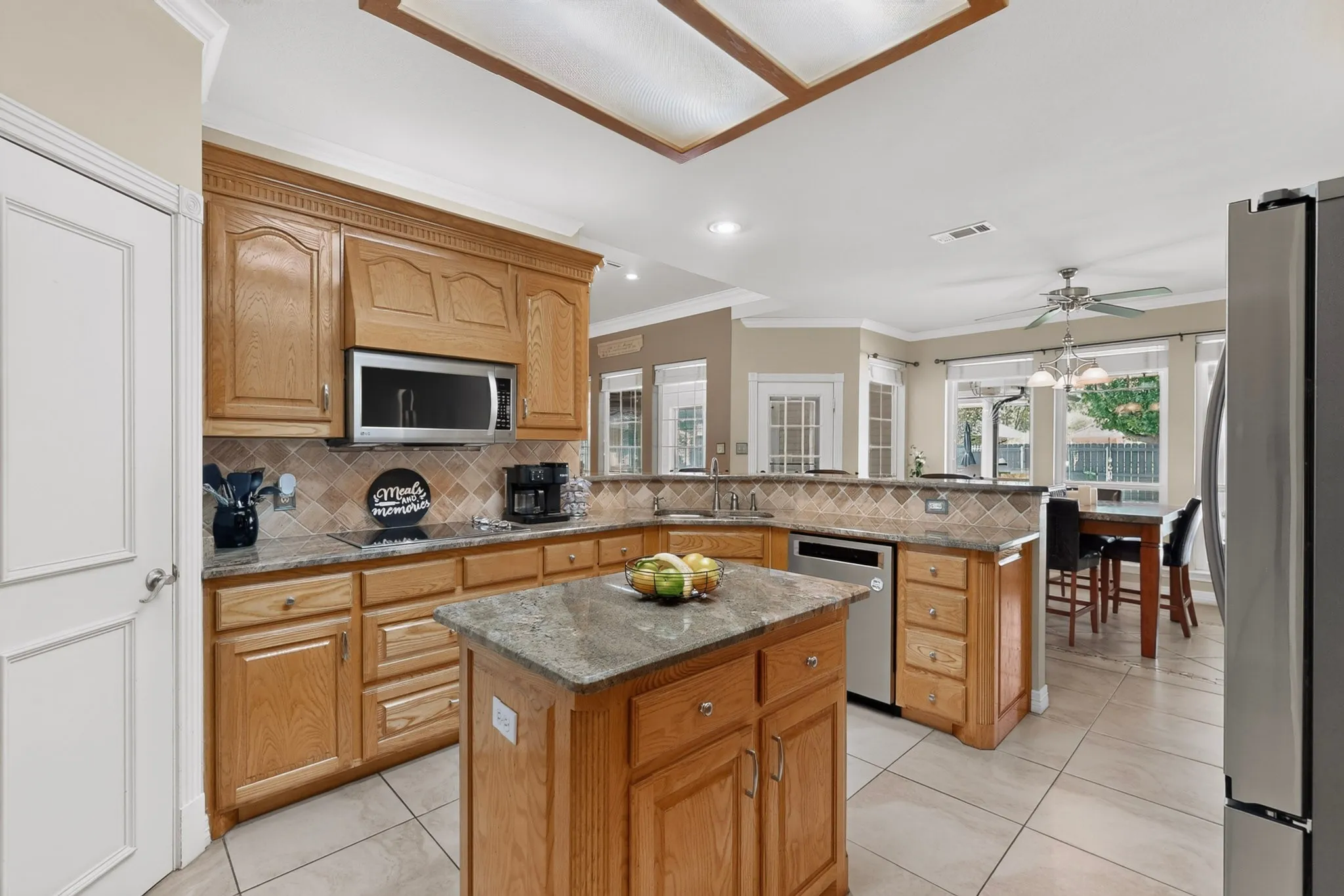 Kitchen featuring wood cabinetry, an island, stainless steel appliances, and a tile backsplash