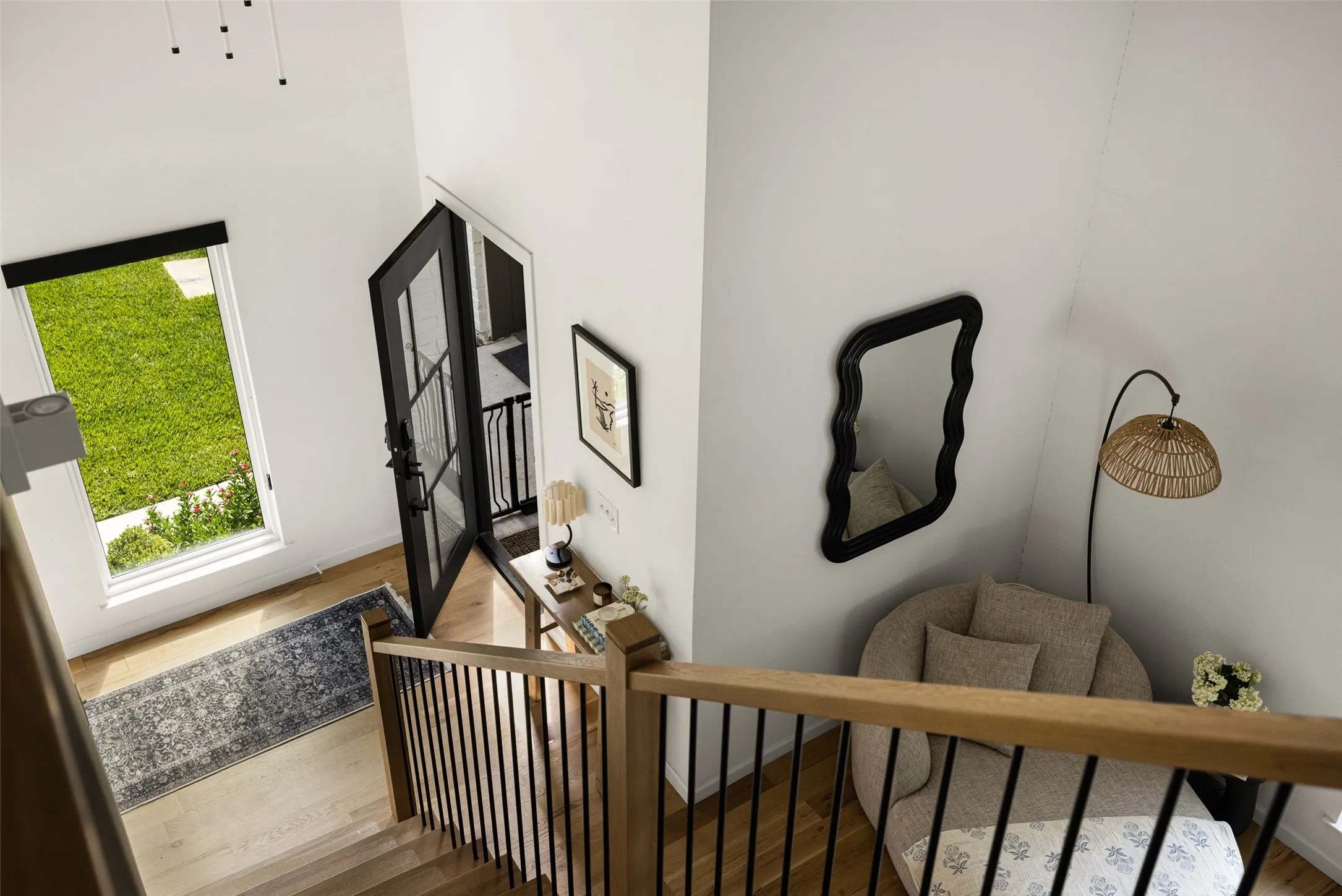 Hardwood flooring, black framed glass door, wood and metal staircase, high ceilings, large window