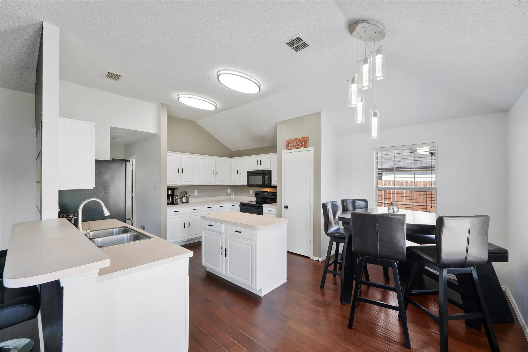Kitchen featuring white cabinetry, light-toned countertops, and wood-finish flooring