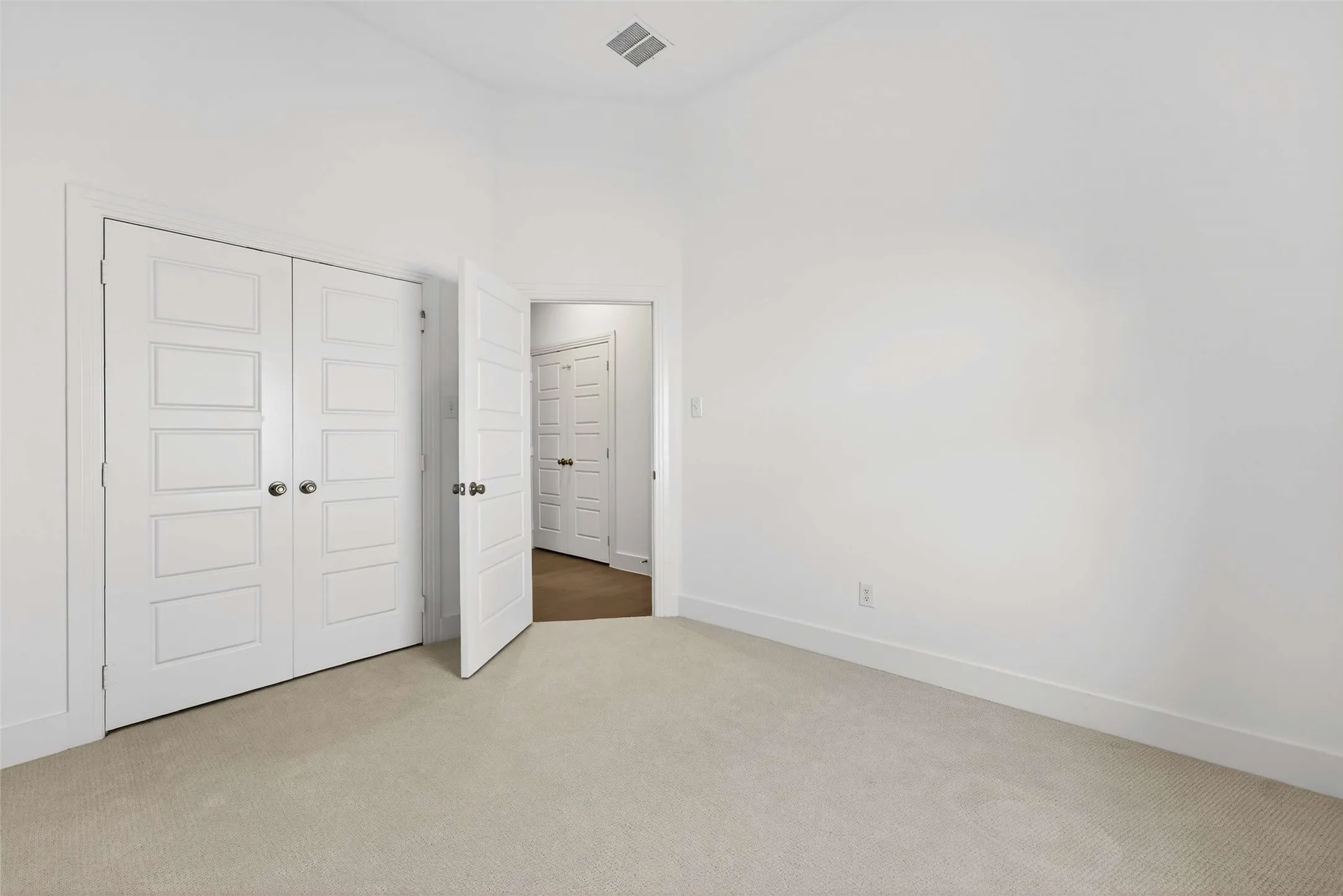 White paneled doors with chrome hardware, neutral carpeting, and a light wall finish