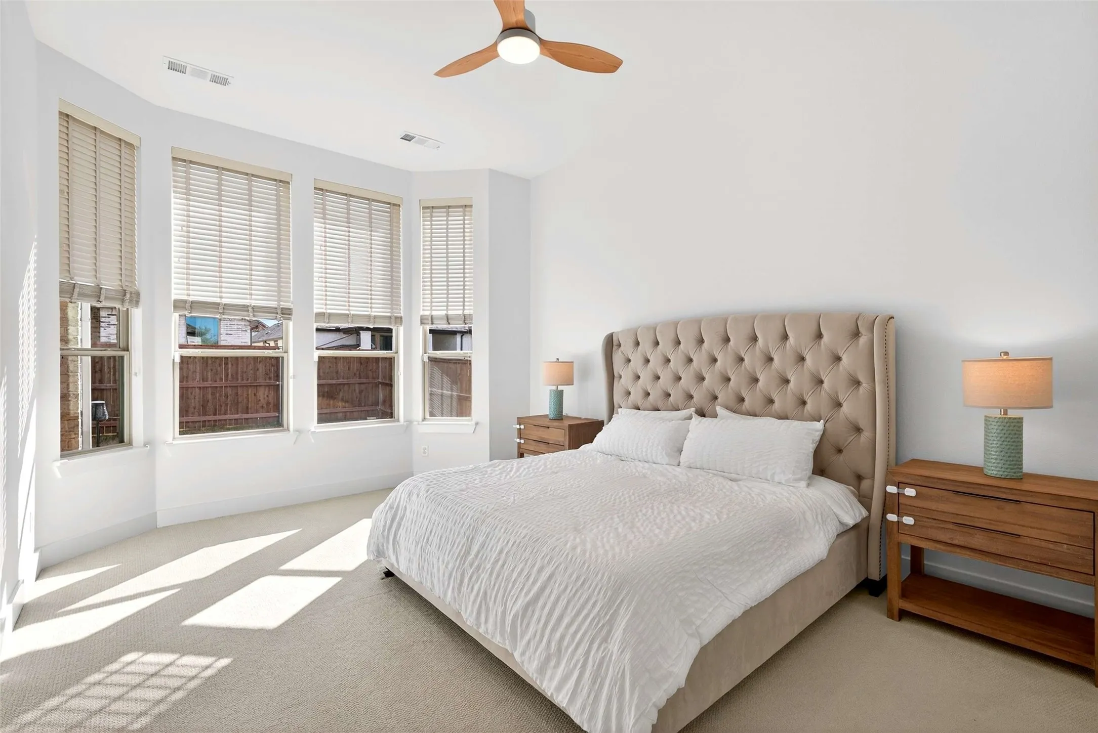 Recessed lighting, ceiling fan, carpeting, bay window, and white walls