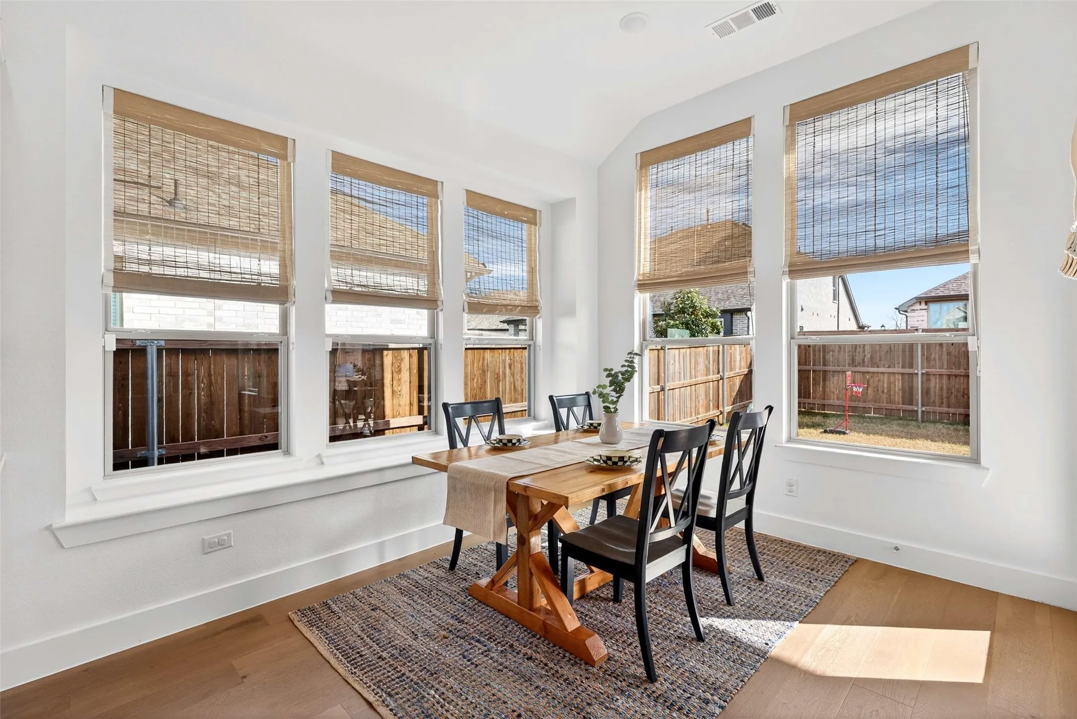Room featuring multiple windows, wood-finish flooring, and white baseboards