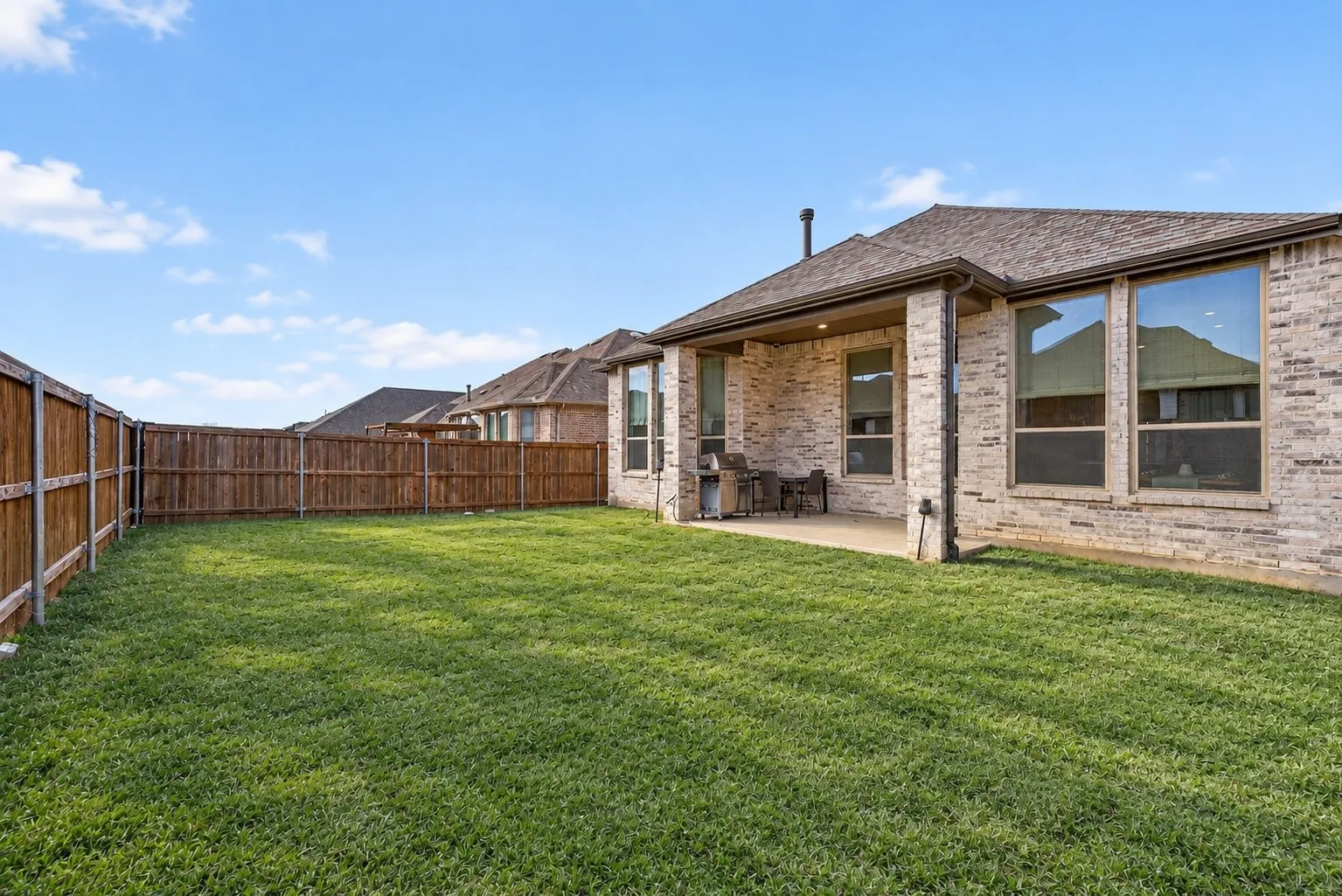 Expansive grassy yard with wood fencing