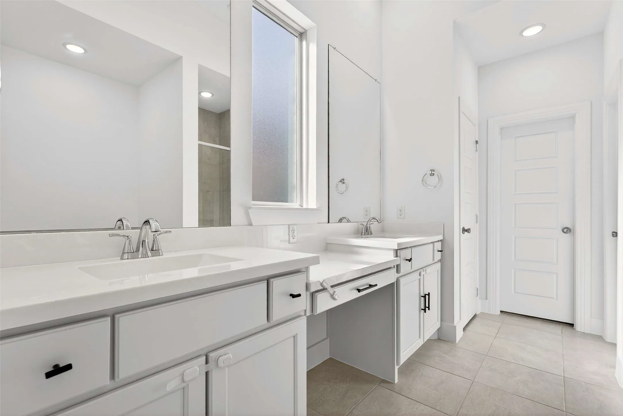 Dual vanity with undermount sinks, white cabinetry, and brushed nickel fixtures