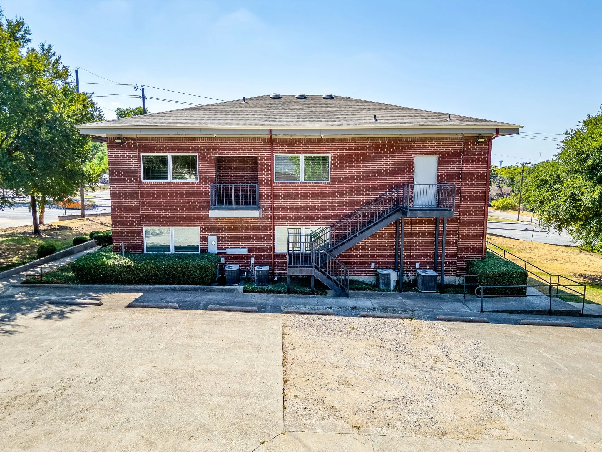 Brick exterior featuring multiple windows and a balcony