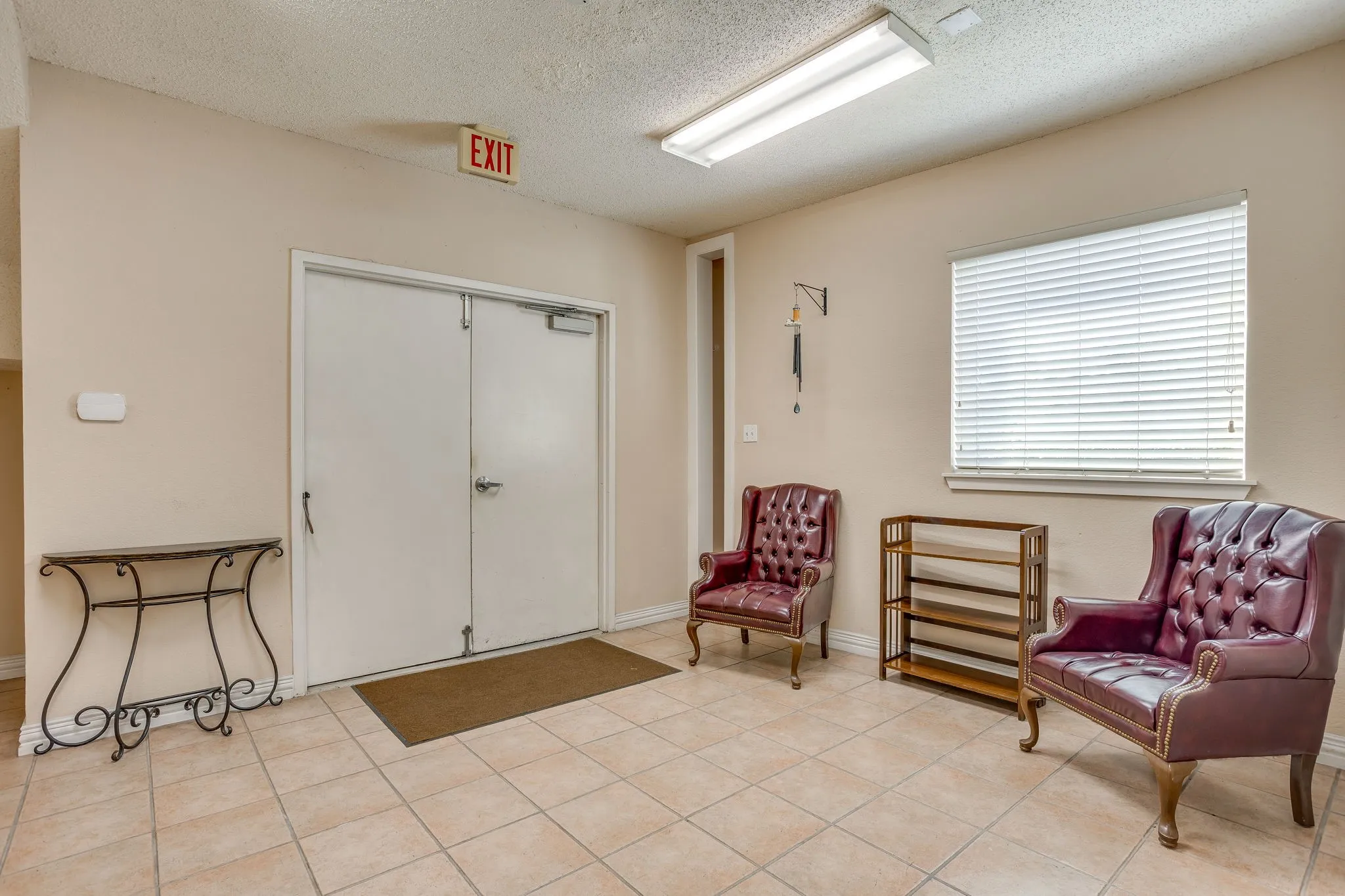 Tile flooring, white double doors, window with blinds, and flush-mount fluorescent lighting