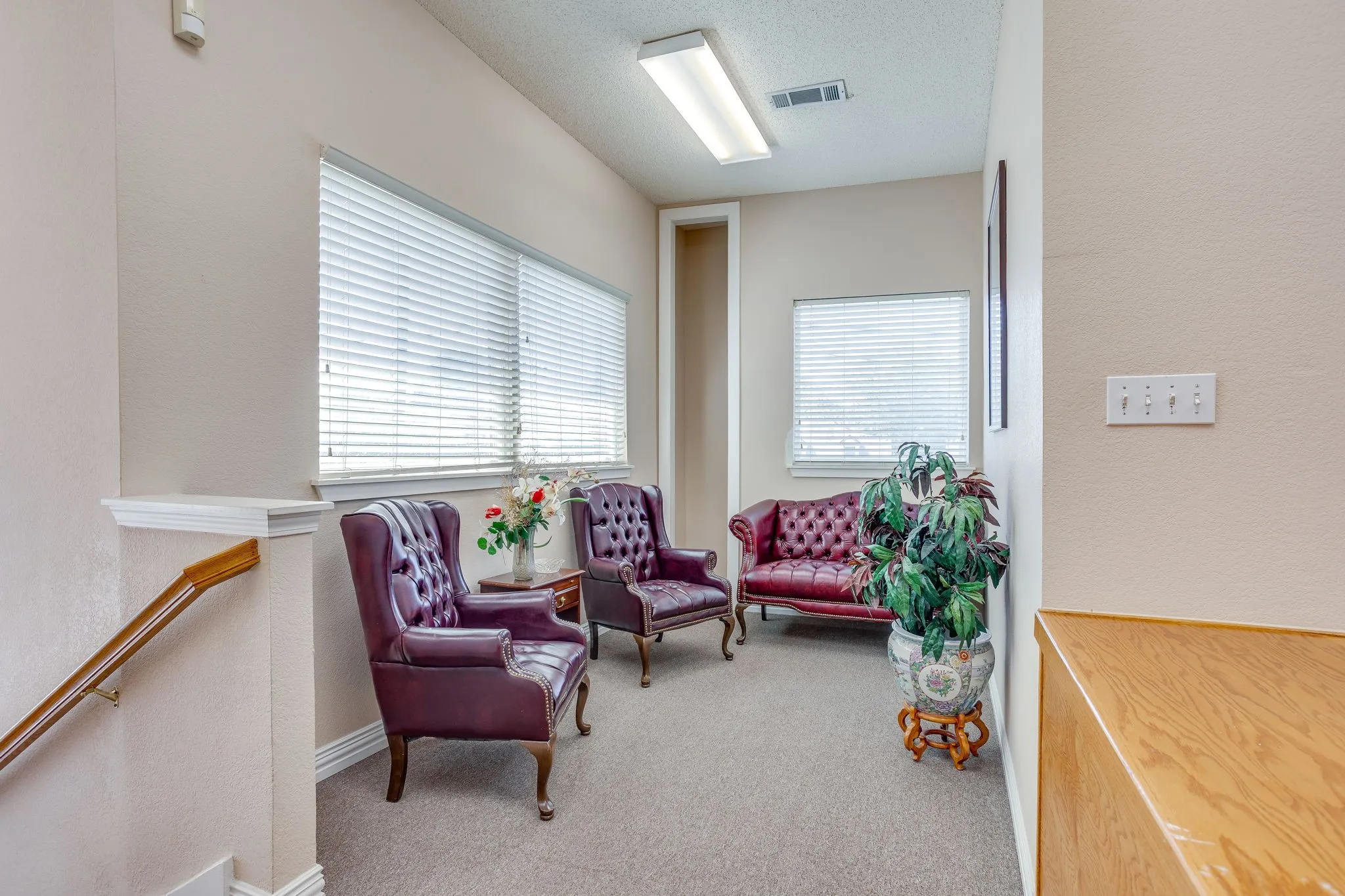 Carpeted area with multiple windows featuring horizontal blinds