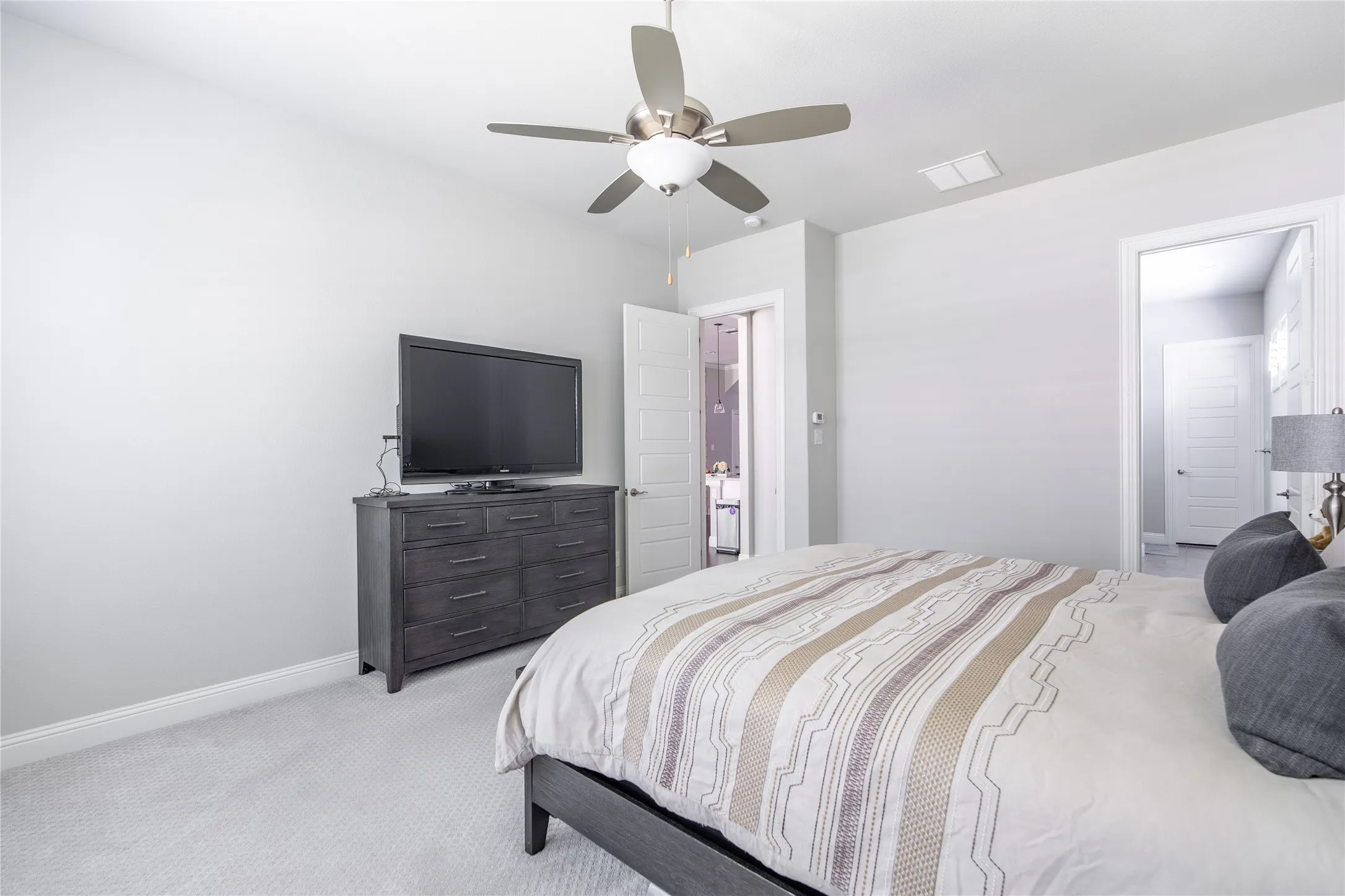Recessed lighting and a ceiling fan fixture illuminate the space
