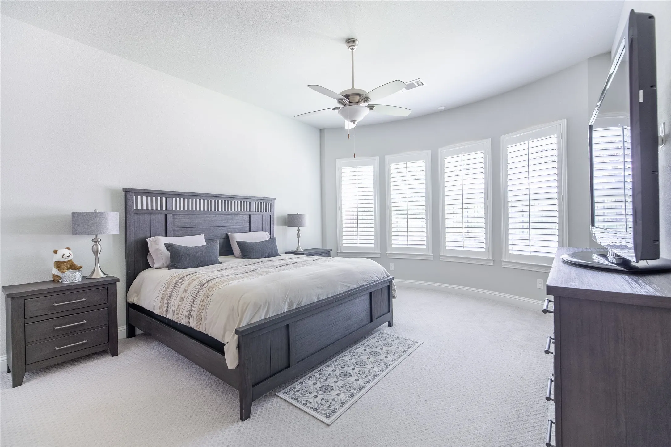 Recessed lighting, ceiling fan with light fixture, and multiple windows with plantation shutters