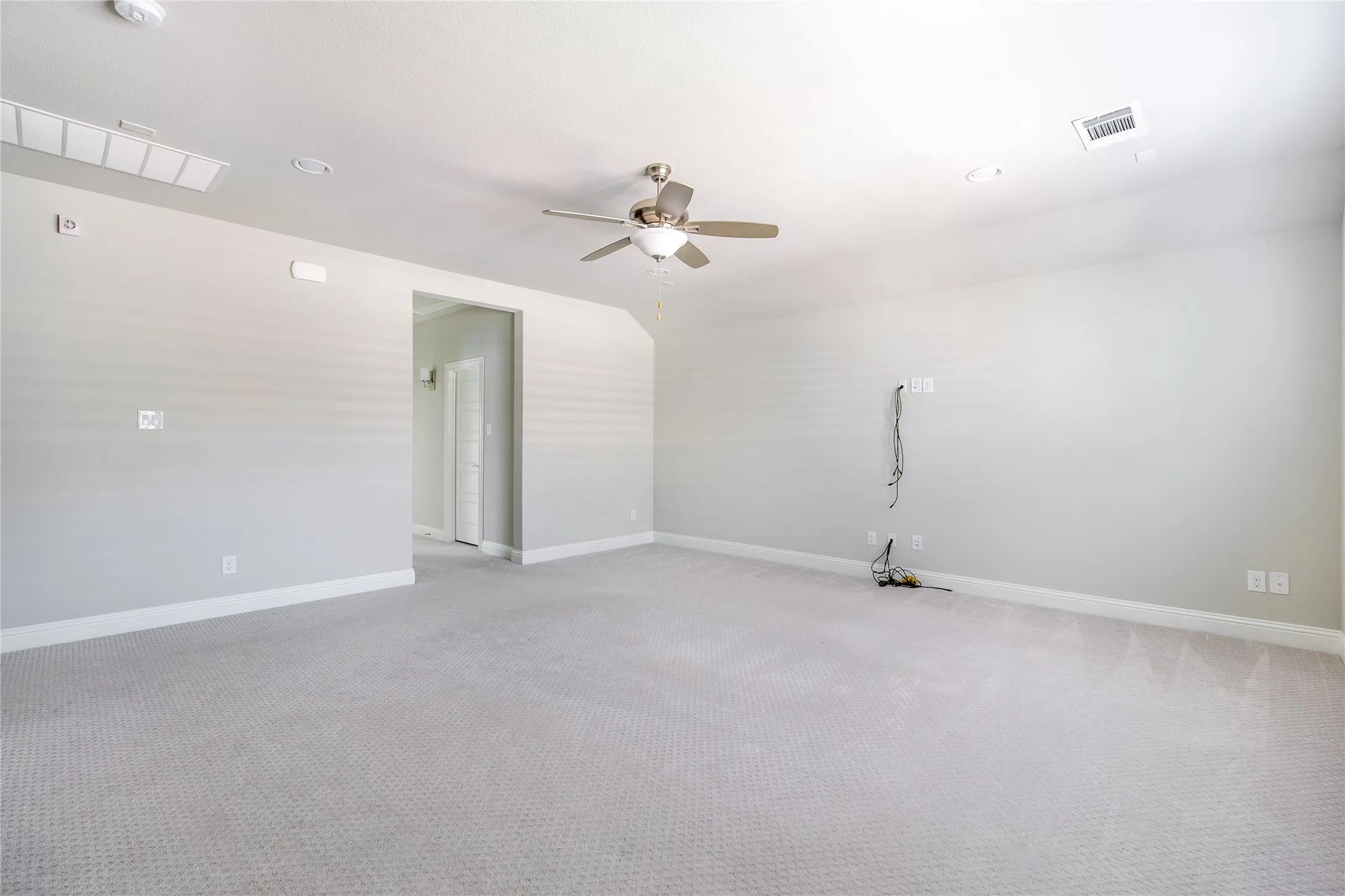 Wall-to-wall carpeting with light gray walls and a ceiling fan