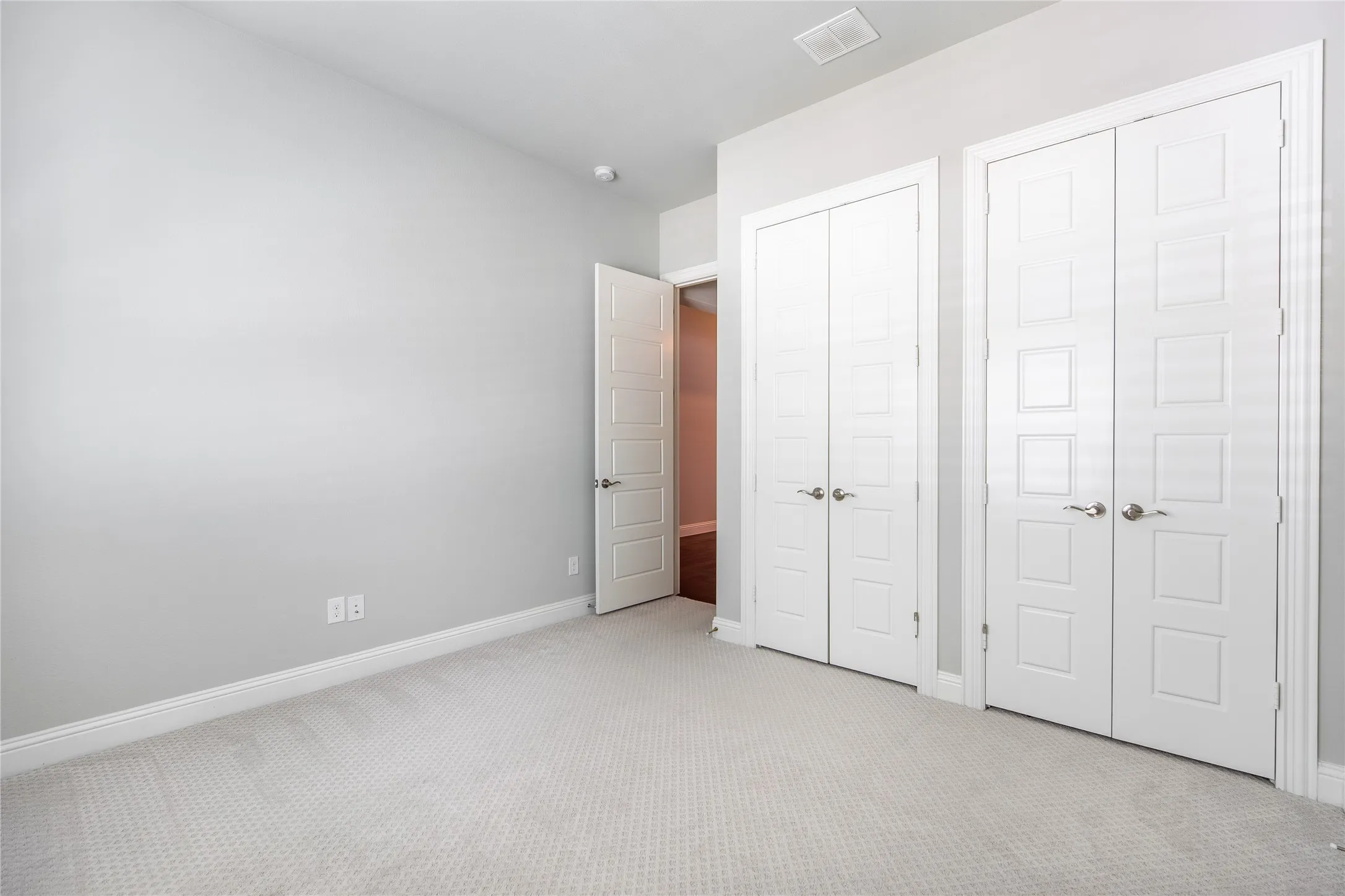 Plush carpeting, bright white paneled doors, and clean wall finishes