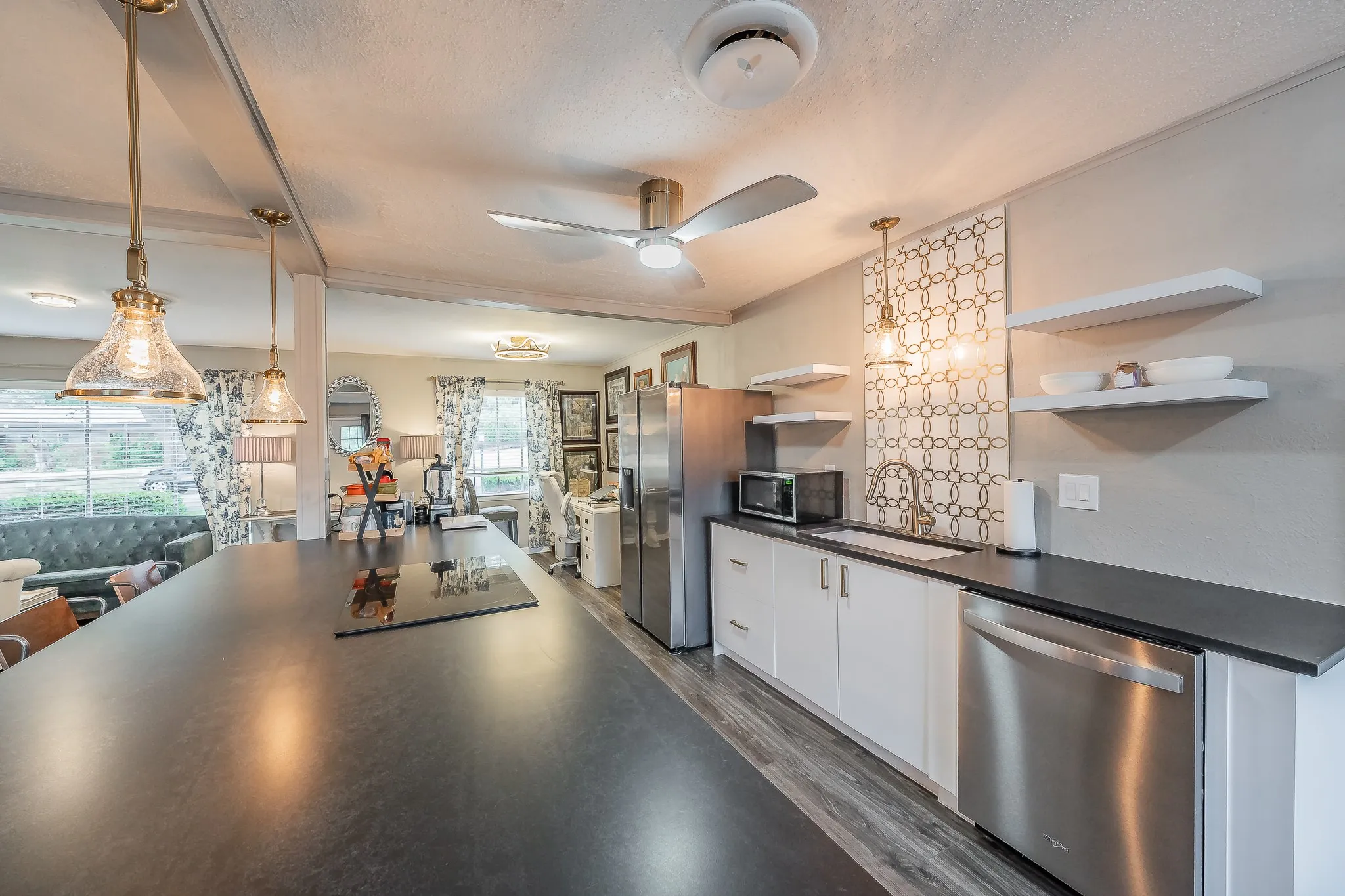 Kitchen featuring a built-in cooktop, stainless steel appliances, white cabinetry, open shelving, and a decorative tile backsplash