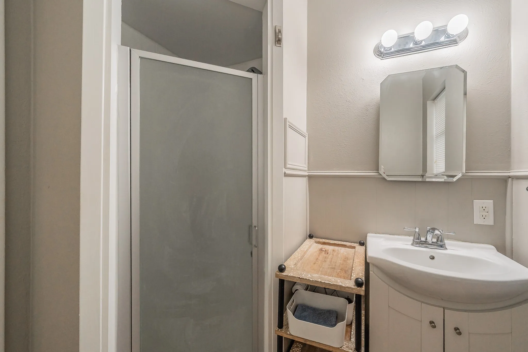 Built-in vanity with under-sink cabinetry, wall-mounted mirror, and overhead lighting fixture