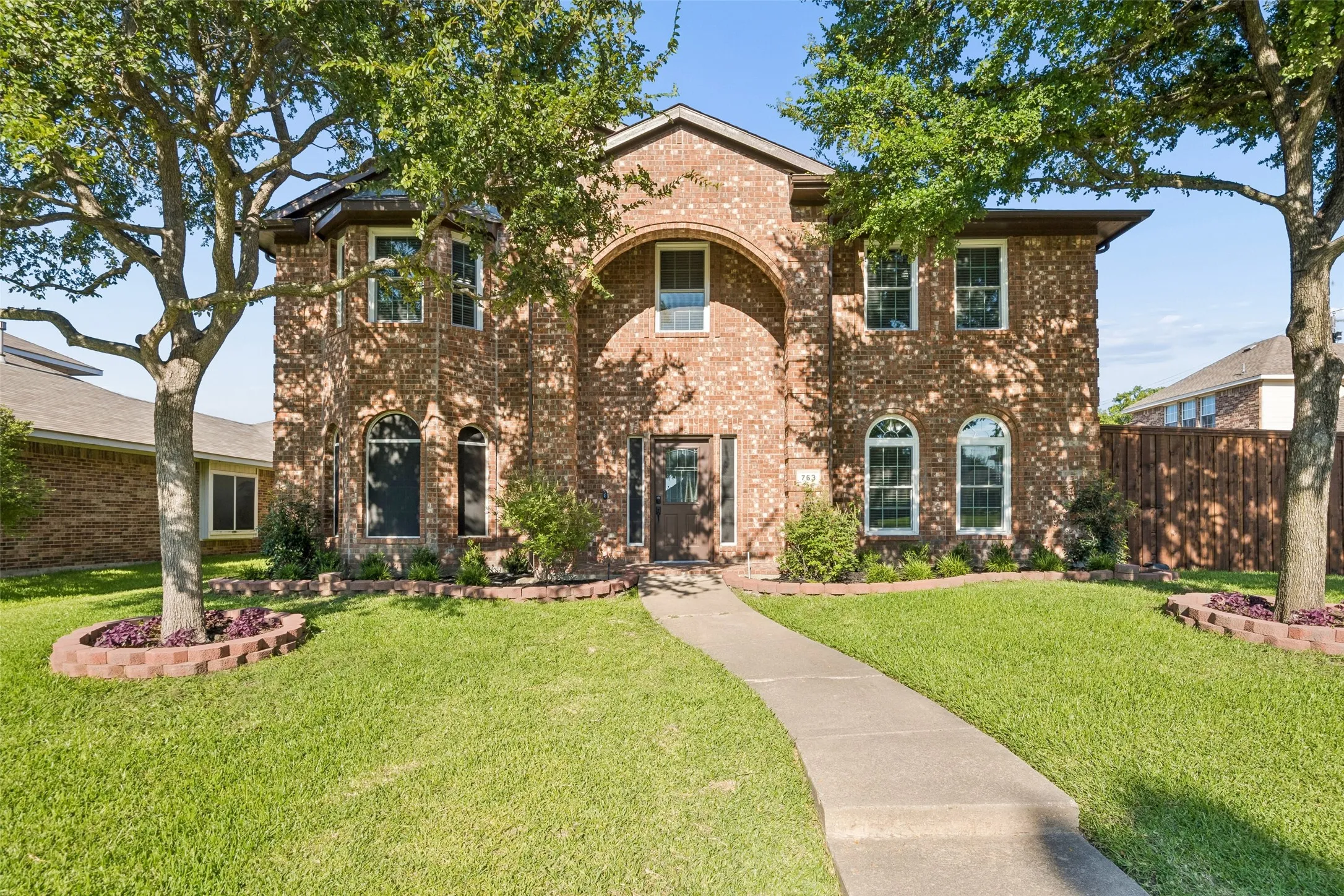 Brick exterior with arched entry and bay window feature