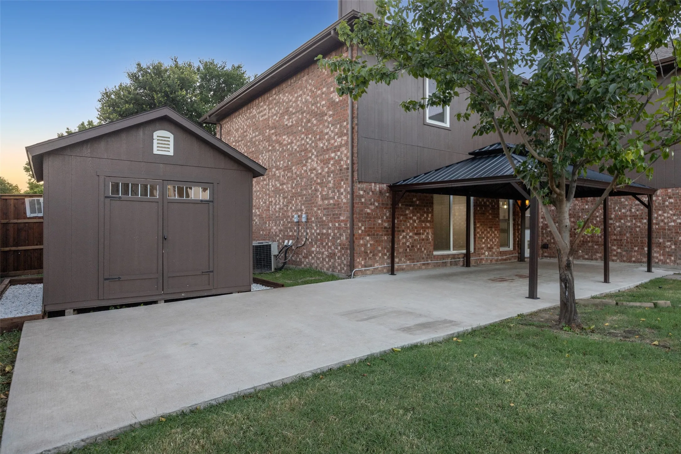 Brick exterior, covered patio, concrete pathway, detached storage shed, privacy fence