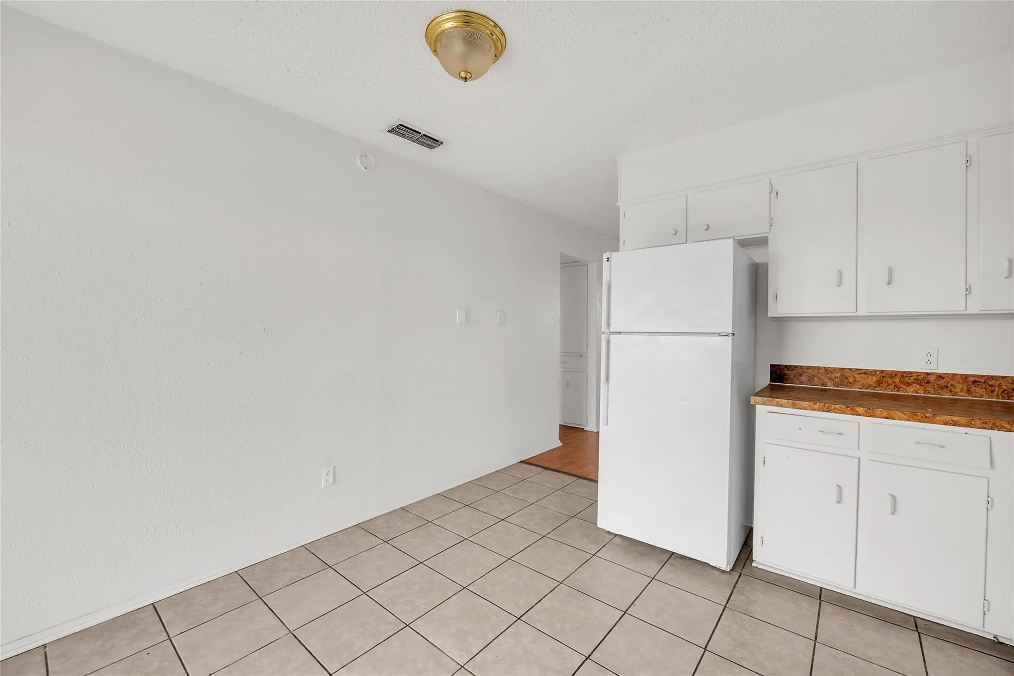 Tile flooring with white walls and a white cabinetry