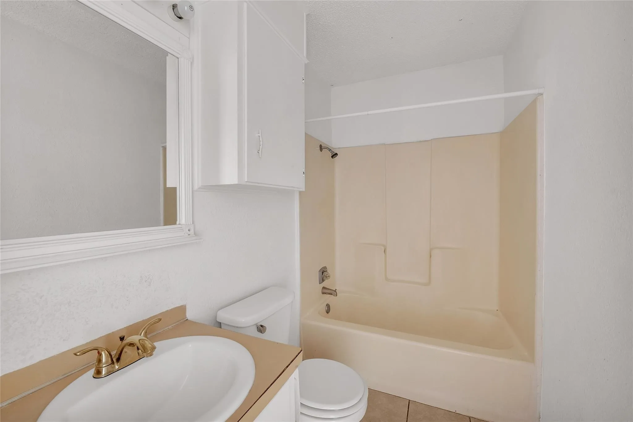 Bathroom featuring a vanity with an integrated sink, polished brass-finish faucet, and a wall-mounted medicine cabinet