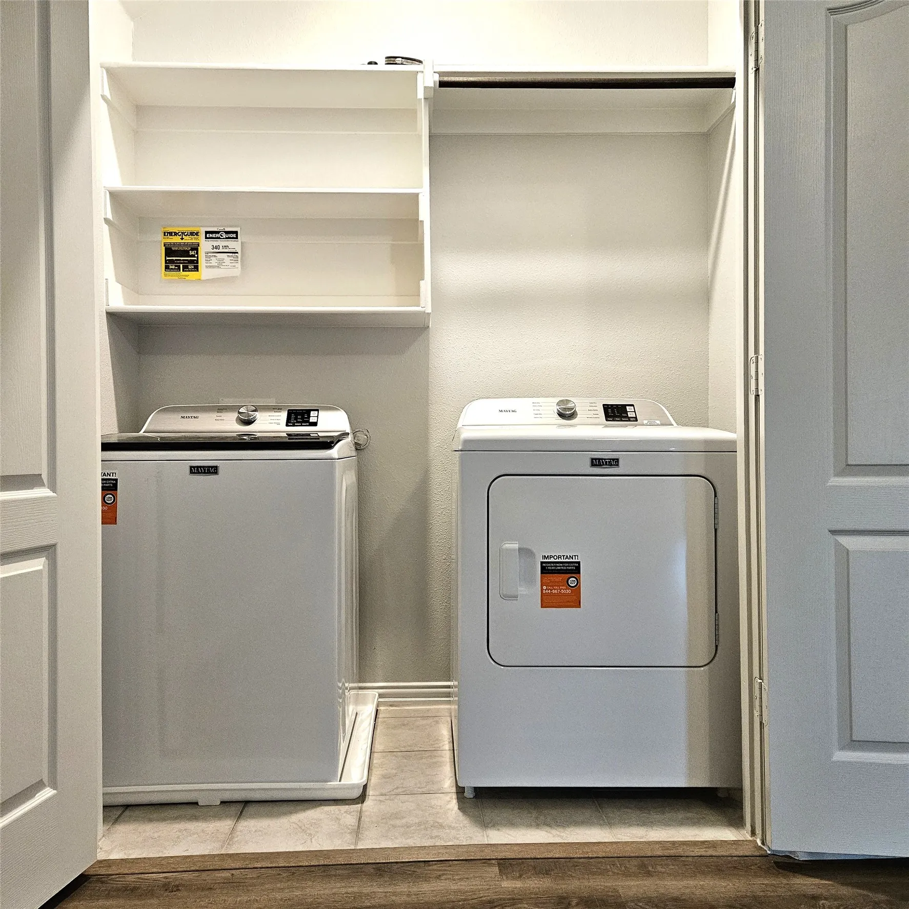 Dedicated laundry area with built-in shelving, a clothes rod, and tile flooring