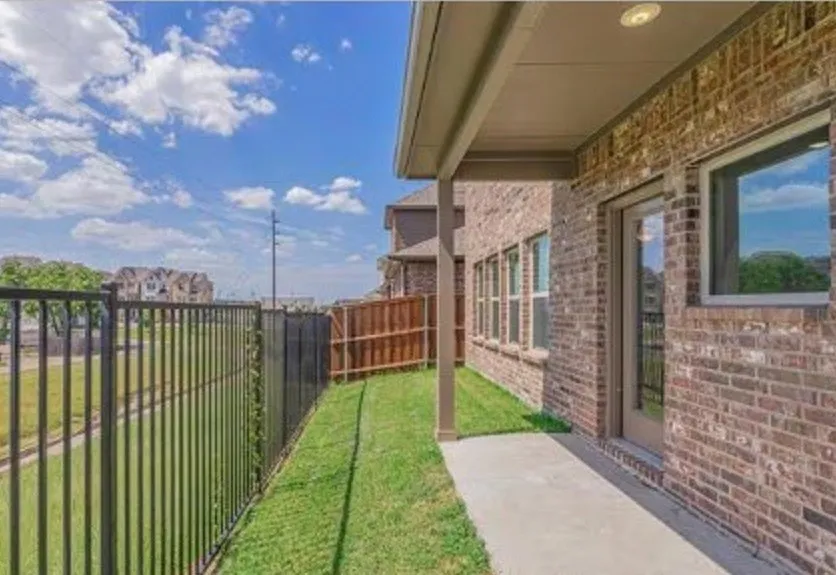 Covered concrete patio with brick exterior and recessed lighting