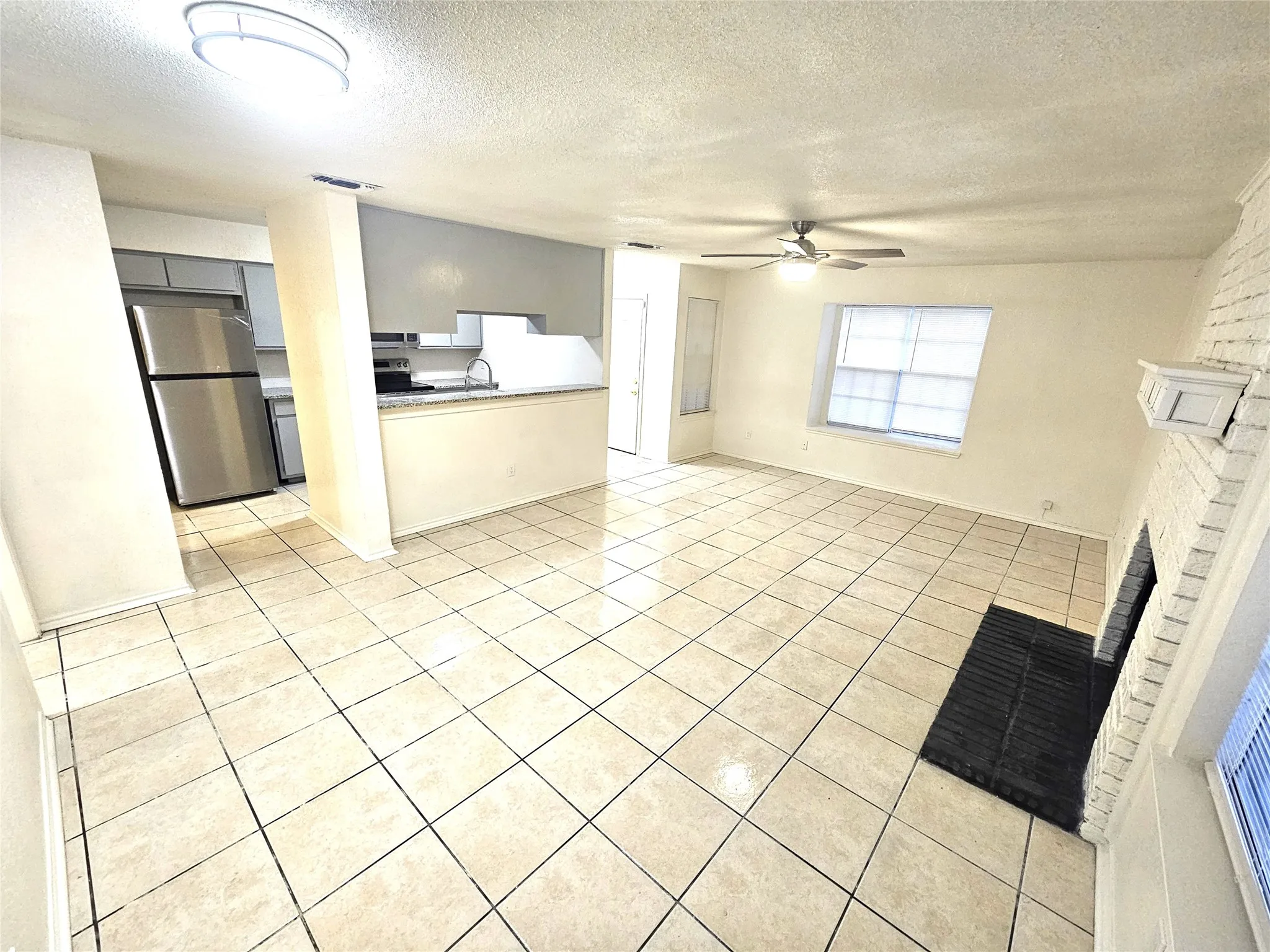 open concept living room with big windows and fireplace (3425 Republic)