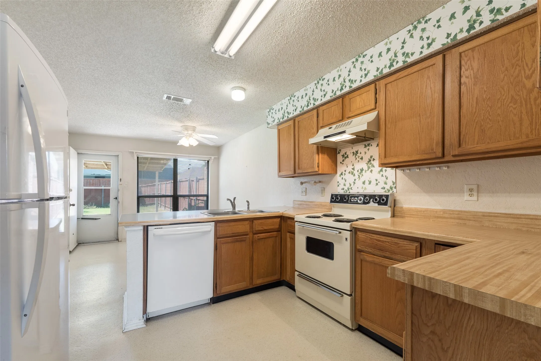 Looking from entry from dining room to kitchen, breakfast eat-in area and towards the backyard.