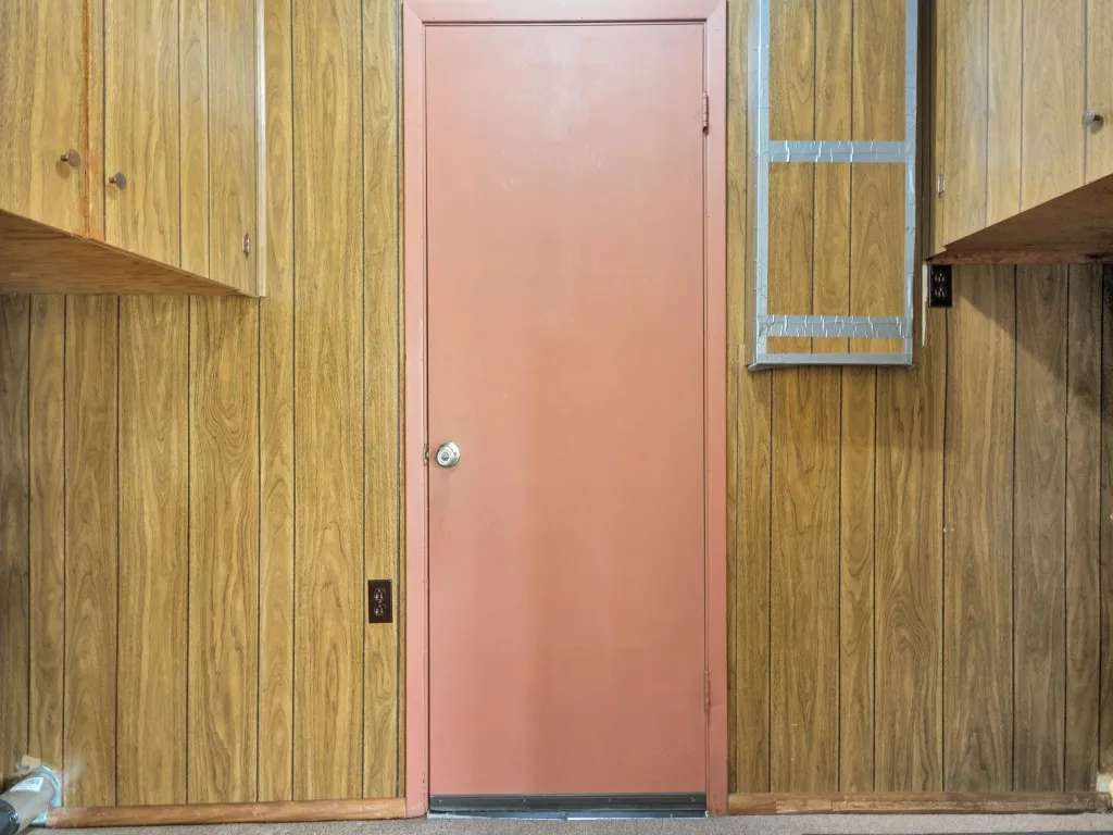 The large utility room has washer and dryer connections and built-in cabinets.  The doorway leads to the garage.