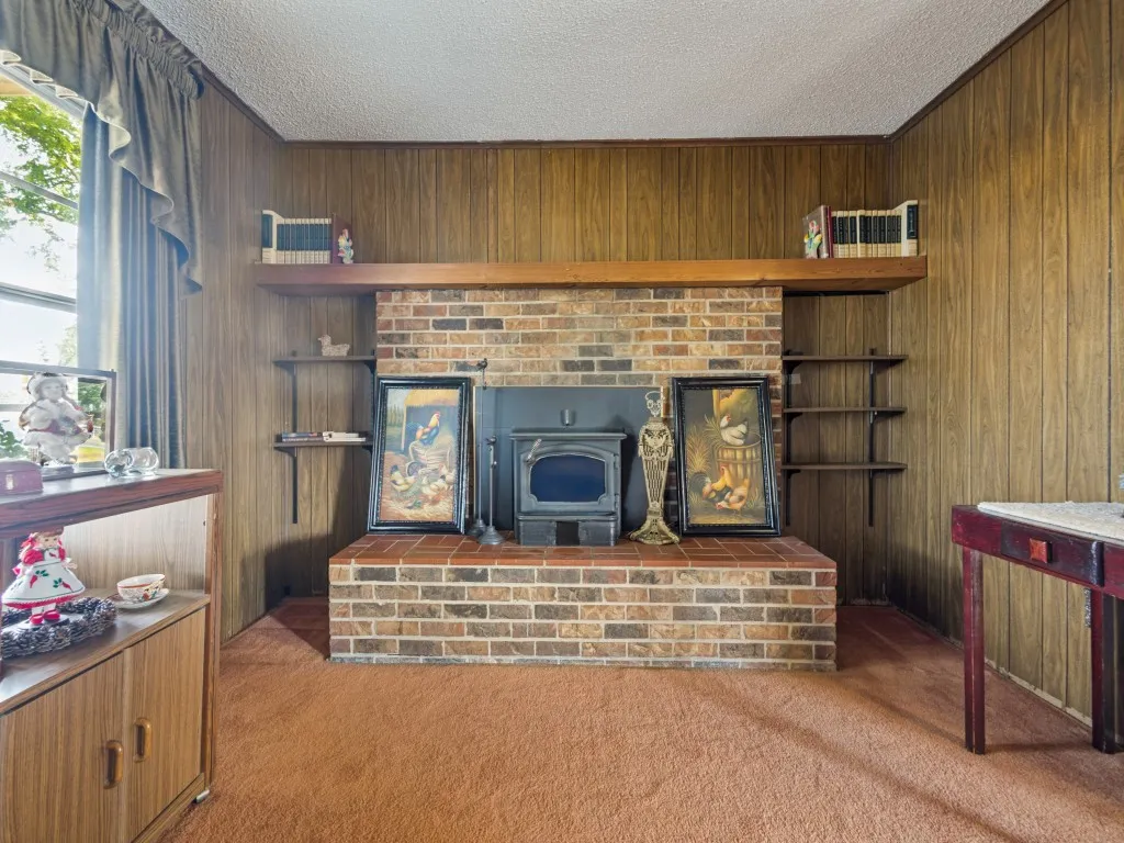 The living room's focal point is this woodburning stove fireplace with brick surround.