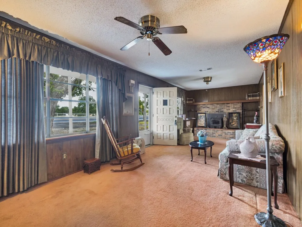 Large living room at the front of the home with large windows and a storm door to allow lots of natural light.