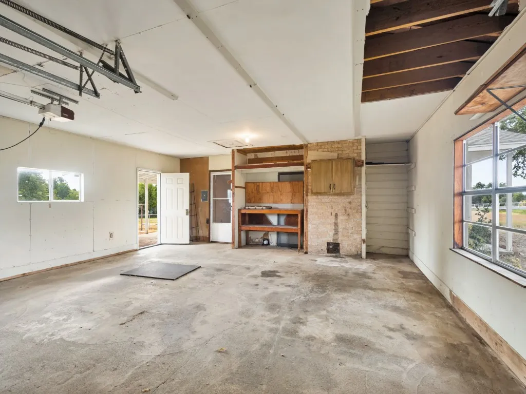 The garage has a door that opens up to the backyard and a door and screen door that enters the home.