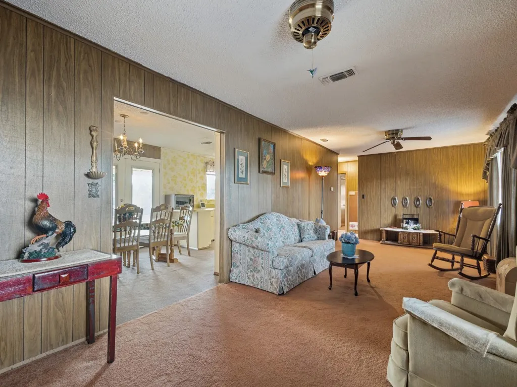 The living room opens up into the dining area on one end and the hallway leading to the bedrooms and bathrooms on the other end.