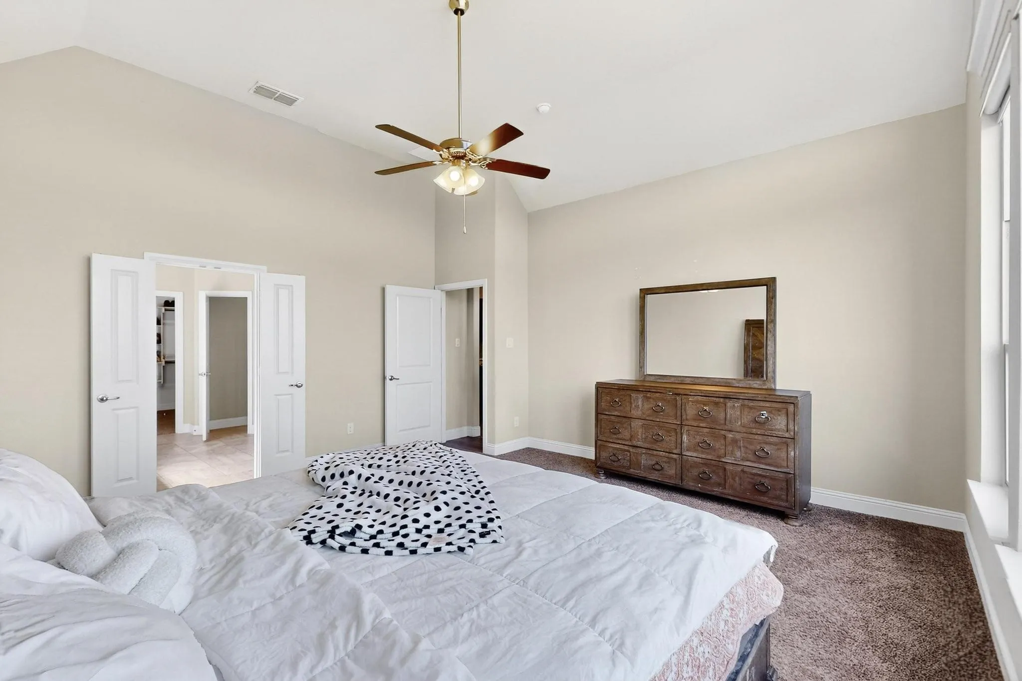 Bedroom featuring high vaulted ceiling, carpet floors, and a ceiling fan