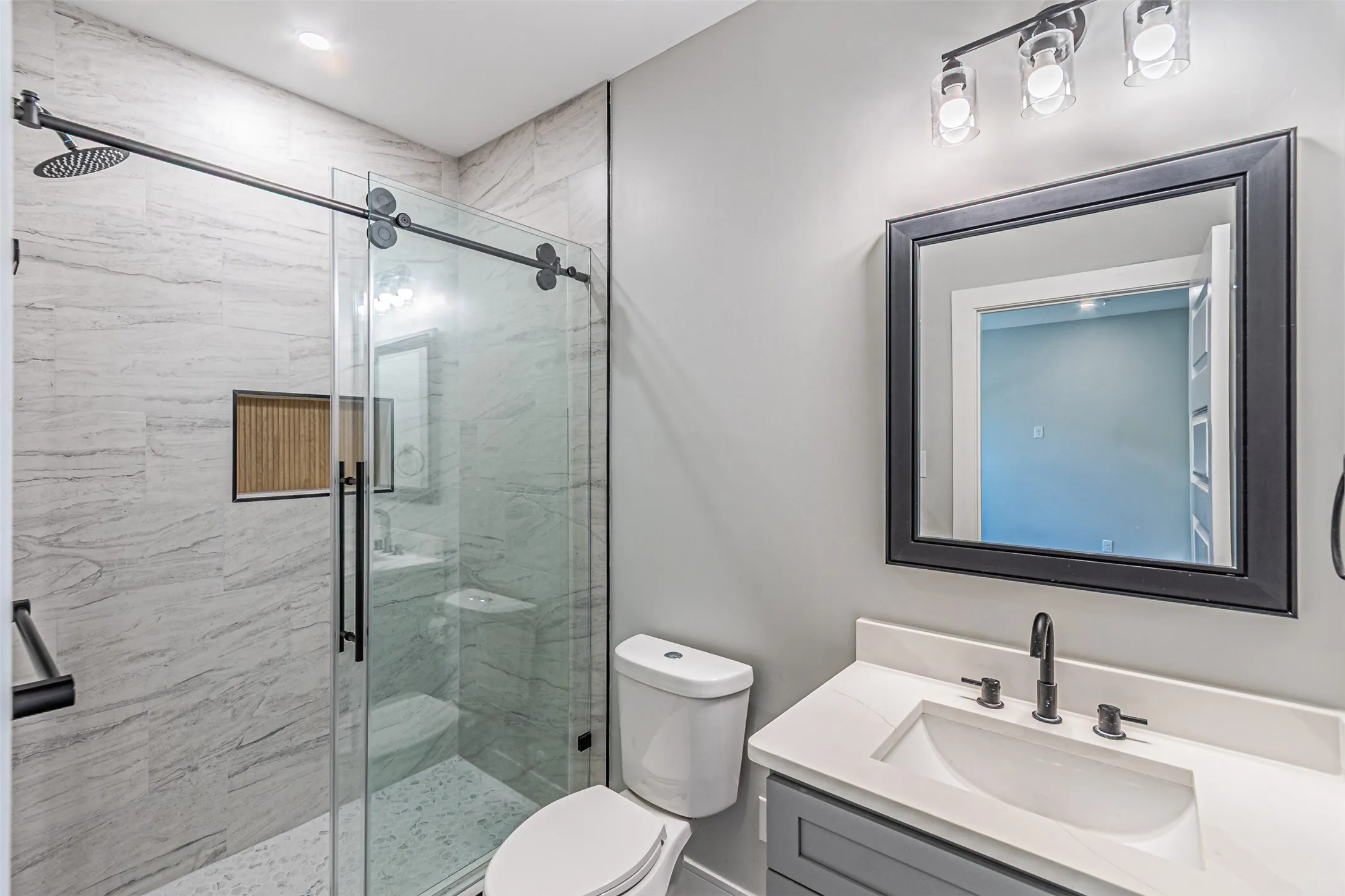 Standing shower for Secondary rooms have sliding glass doors on heavy duty rails.