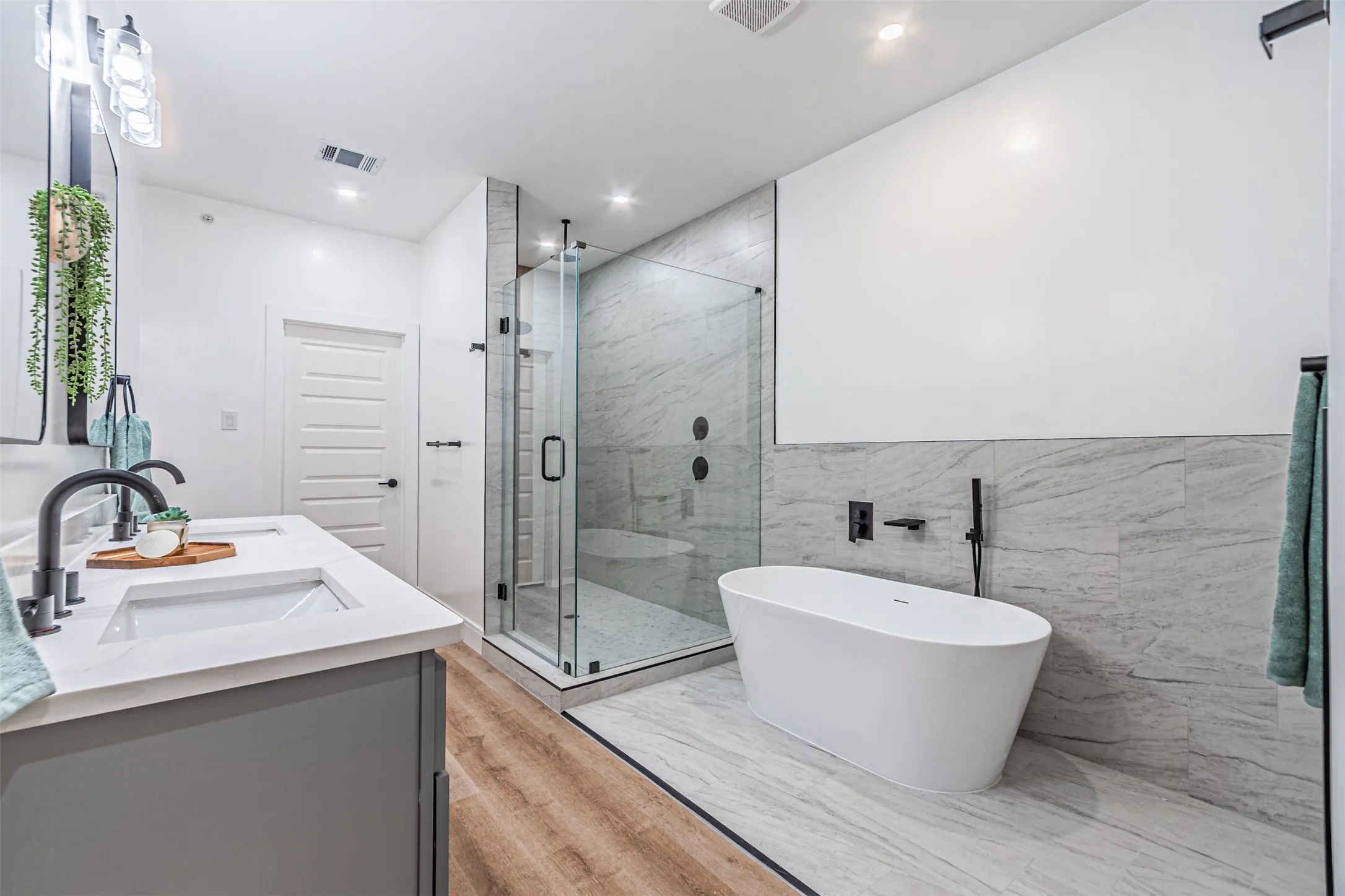 Tub, shower and dual sinks in a luxurious bathroom from where you walk straight into the master closet