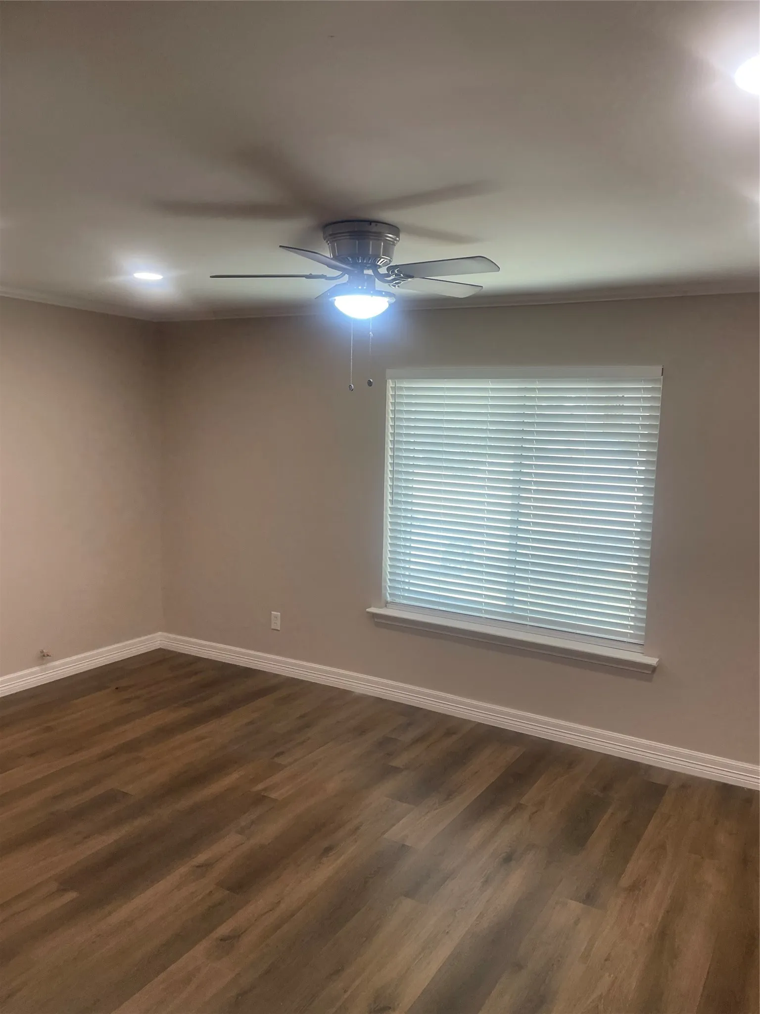 Wood-finish flooring, ceiling fan with integrated lighting, recessed lighting, window with blinds, and painted walls