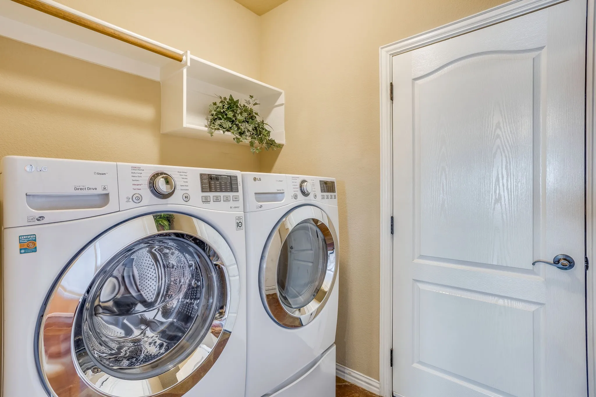 Utility room includes drying bar, shelf storage and space for a fridge or freezer.