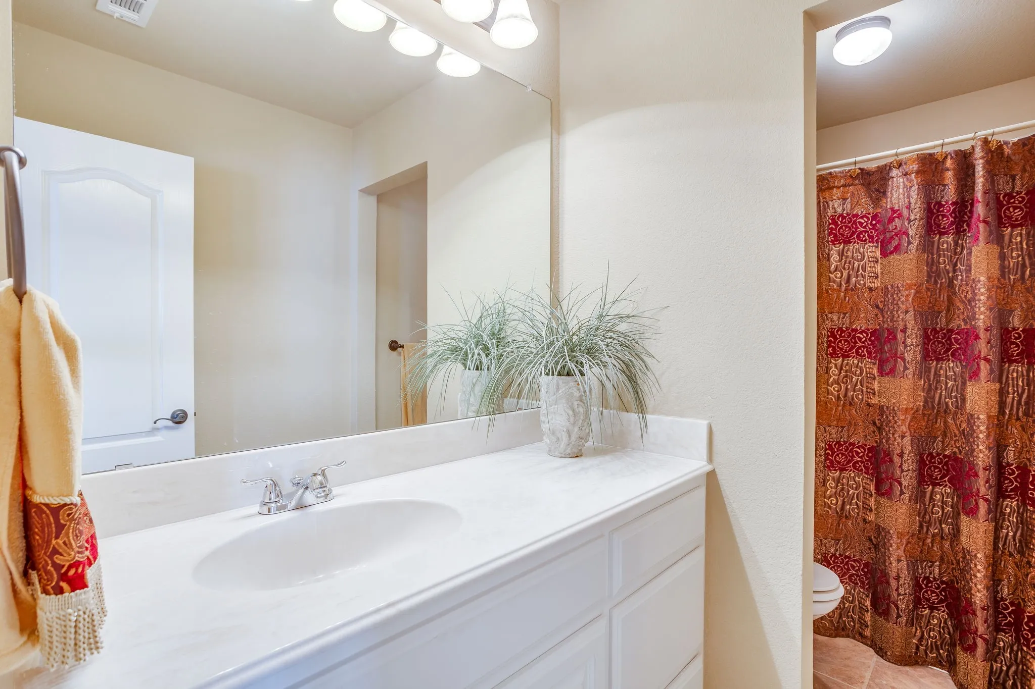 Upstairs guest bathroom in hallway with extended counterspace , shower tub combo and toilet area.