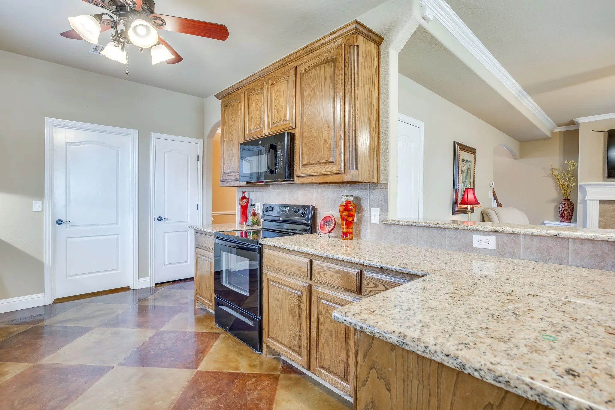 Granite countertops and rich wood cabinets. Black combo oven and range and built in microwave.