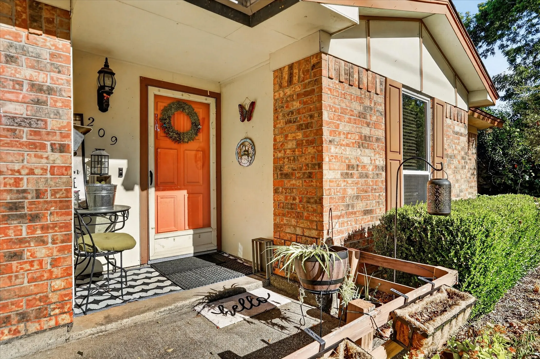 Brick exterior with white trim, covered entryway, and a brightly colored door