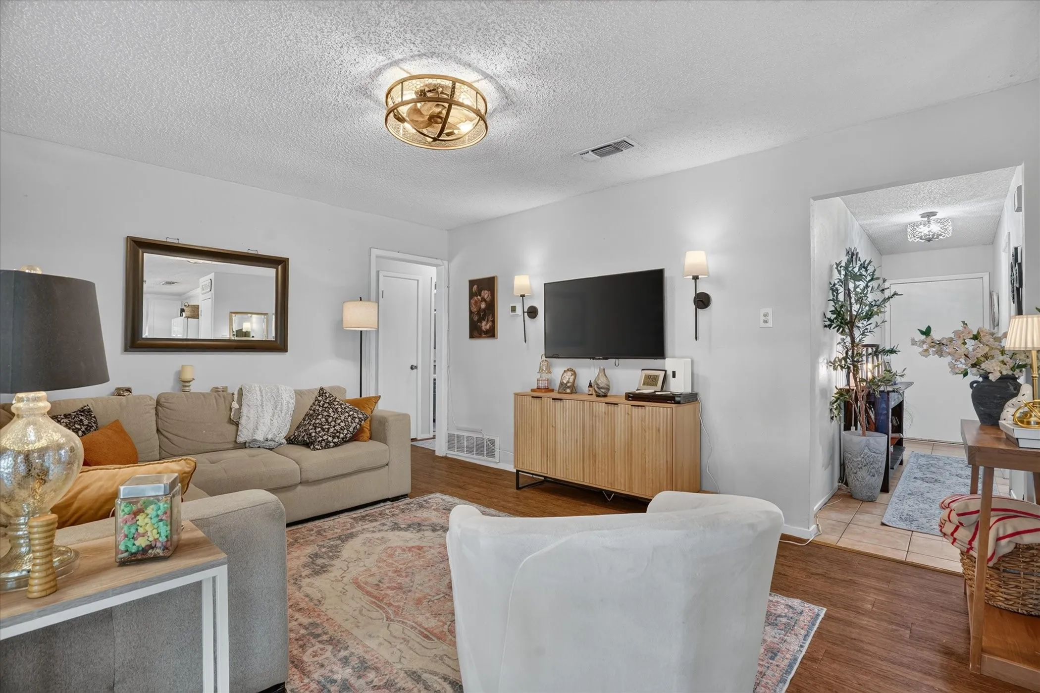 Wood-finish flooring throughout, complemented by a modern ceiling fan with integrated lighting