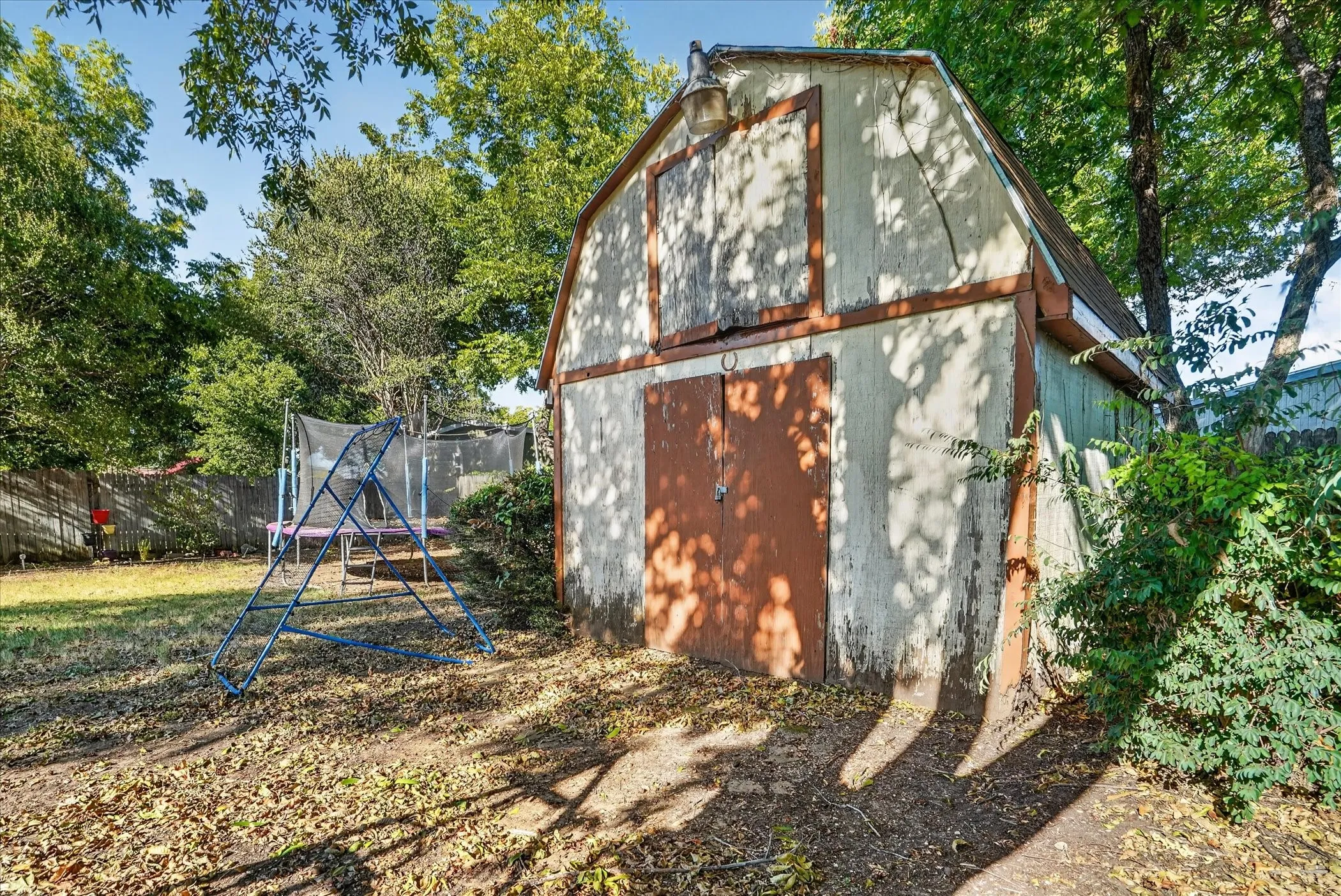 Barn-style shed with double doors and an exterior light fixture